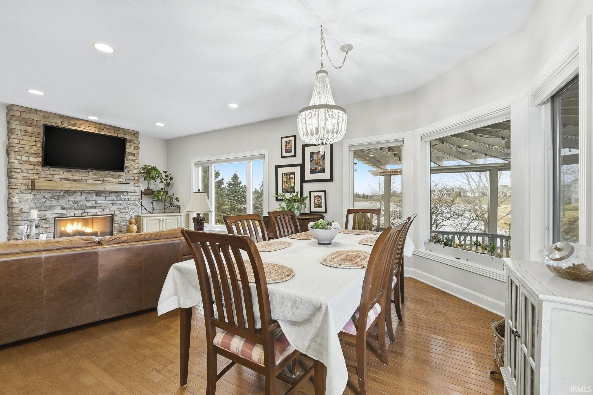 Dining room with hardwood / wood-style flooring, a fireplace, and a chandelier