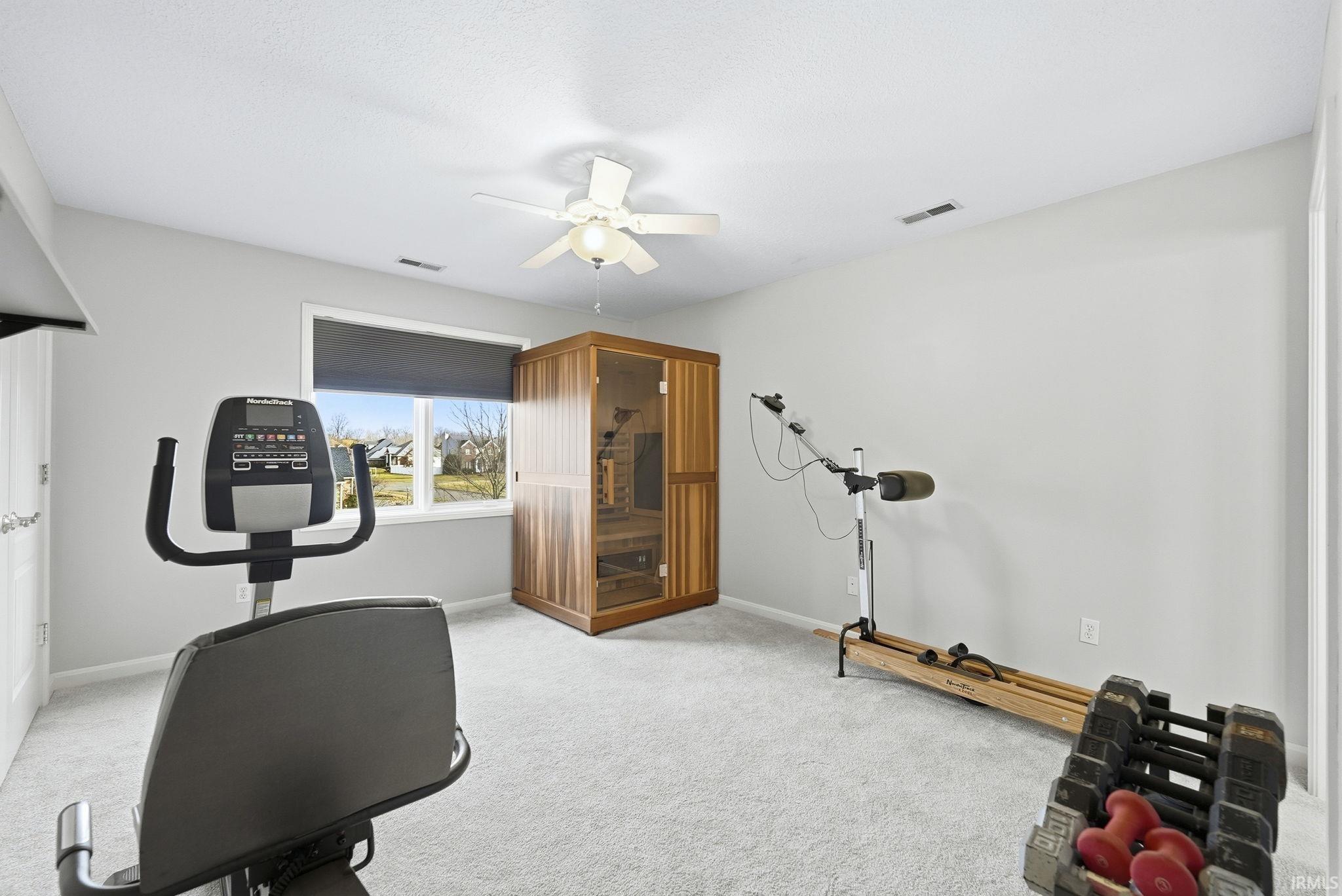 Exercise room featuring a sauna / steam room, carpet floors, and ceiling fan