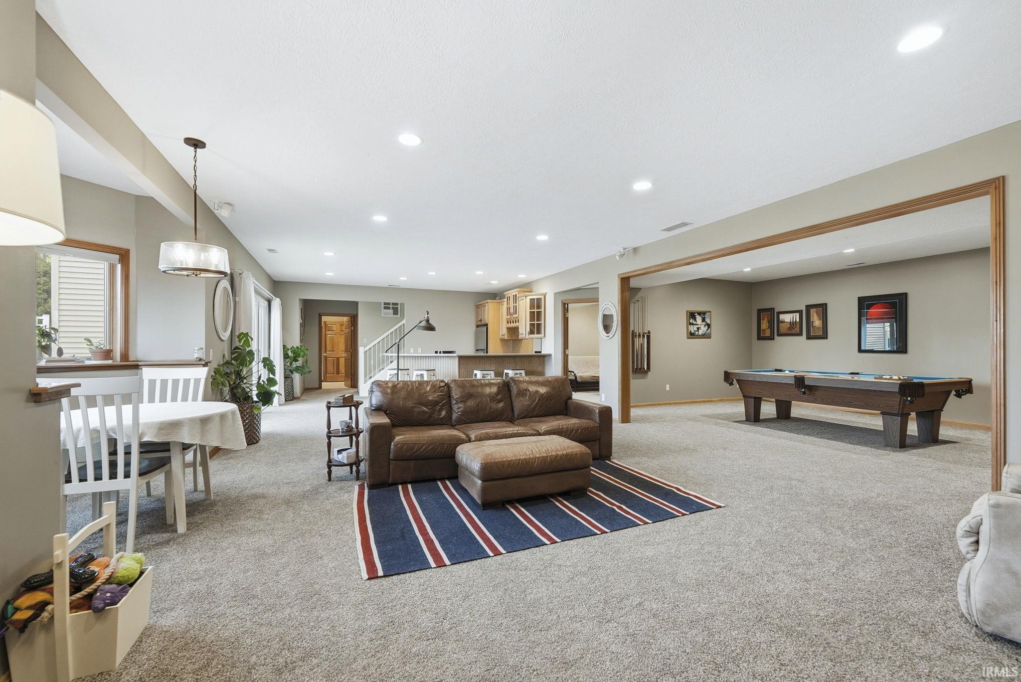 Living room with light colored carpet, pool table, and recessed lighting