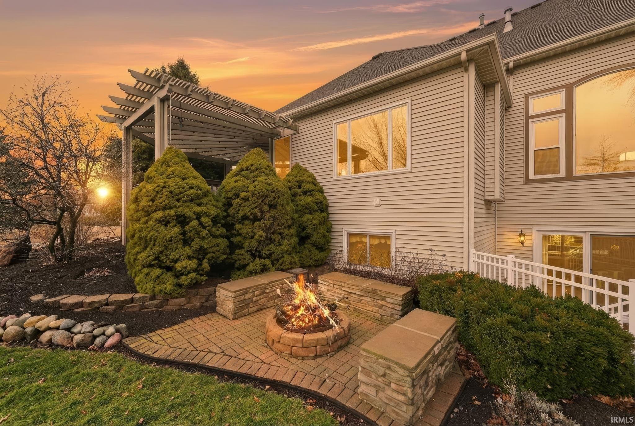 Rear view of house with a patio, a fire pit, and a pergola