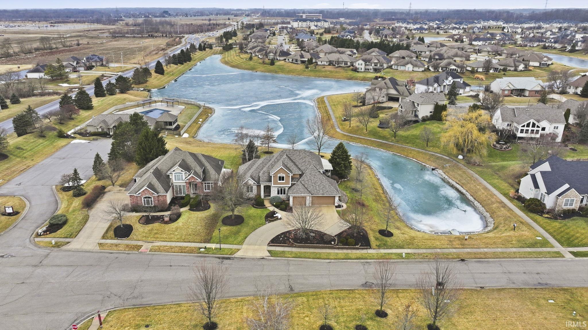 Aerial perspective of suburban area featuring a large body of water