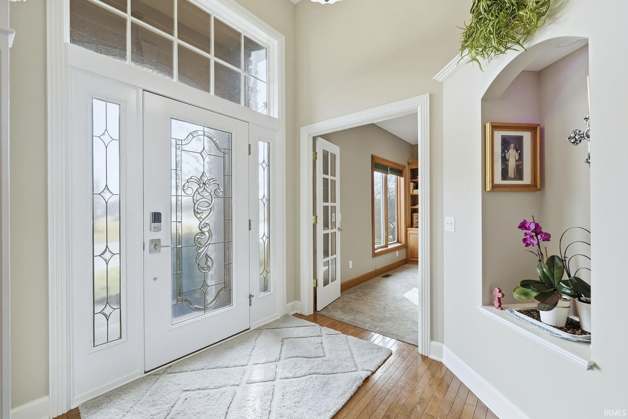 Foyer entrance featuring light wood-style floors and arched walkways