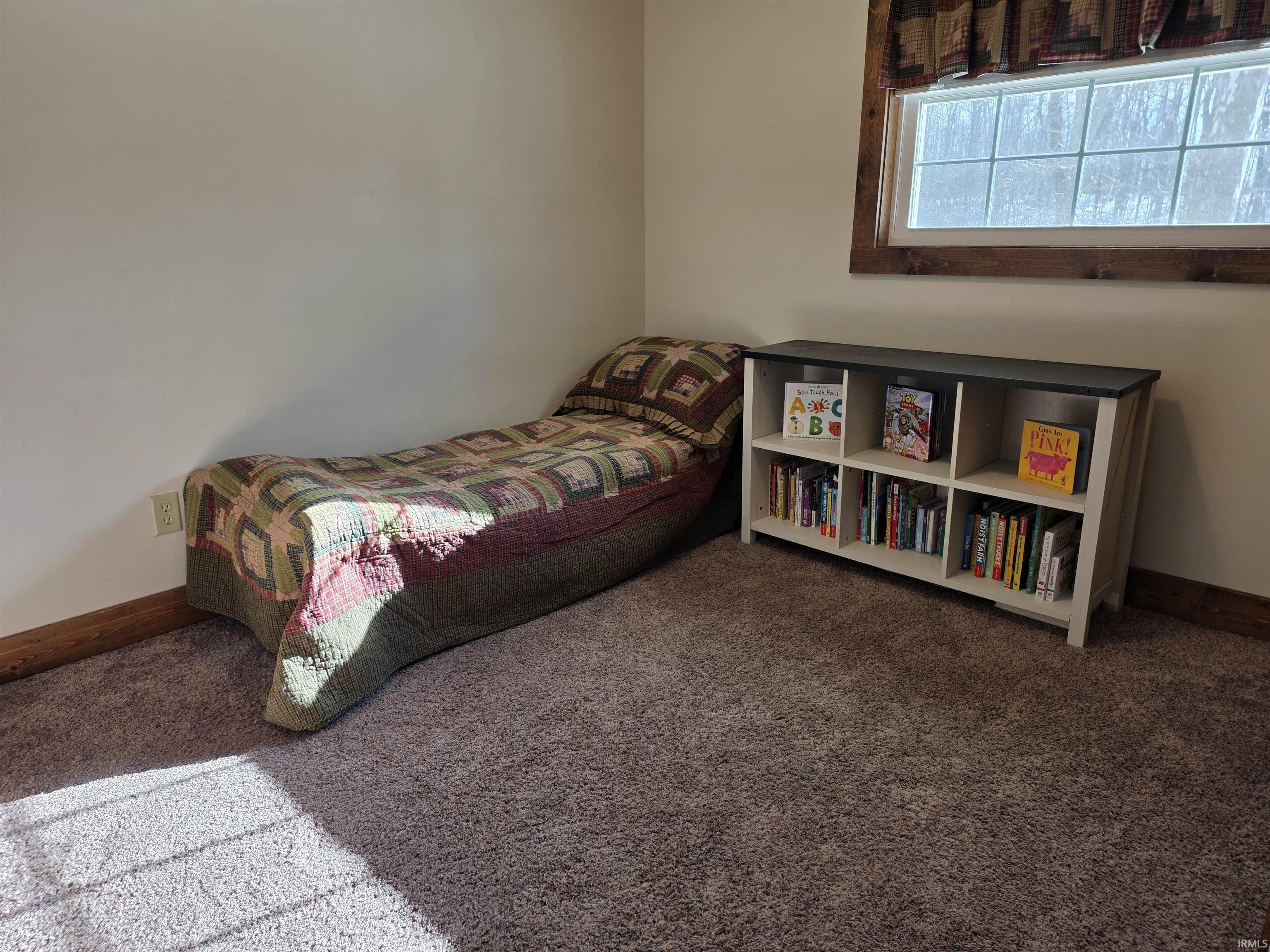 Bedroom featuring baseboards and carpet
