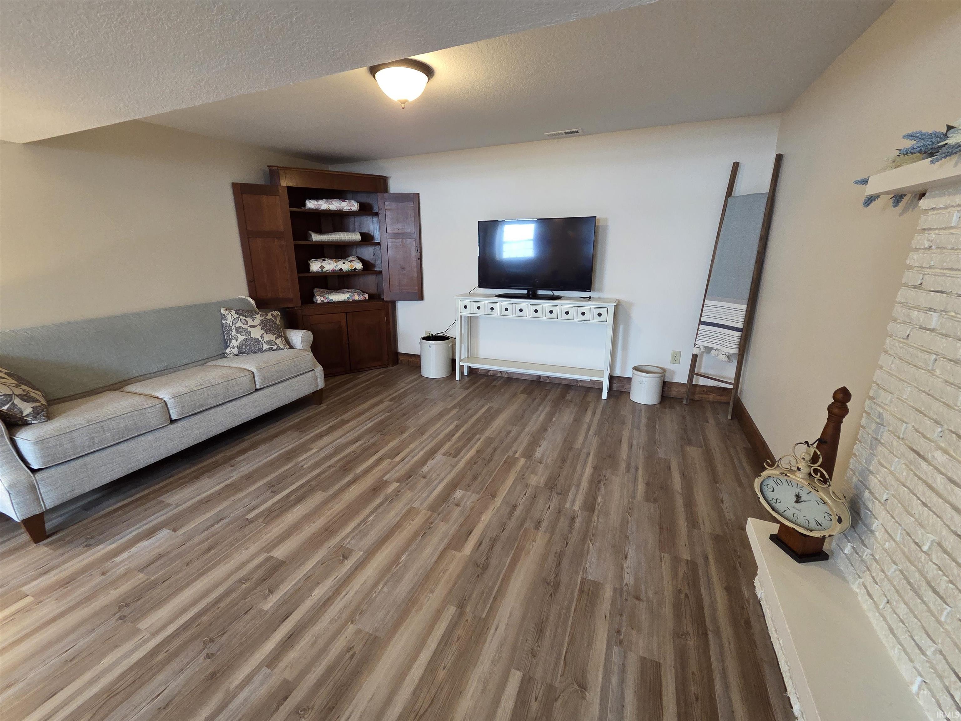 Living area featuring wood finished floors and a textured ceiling