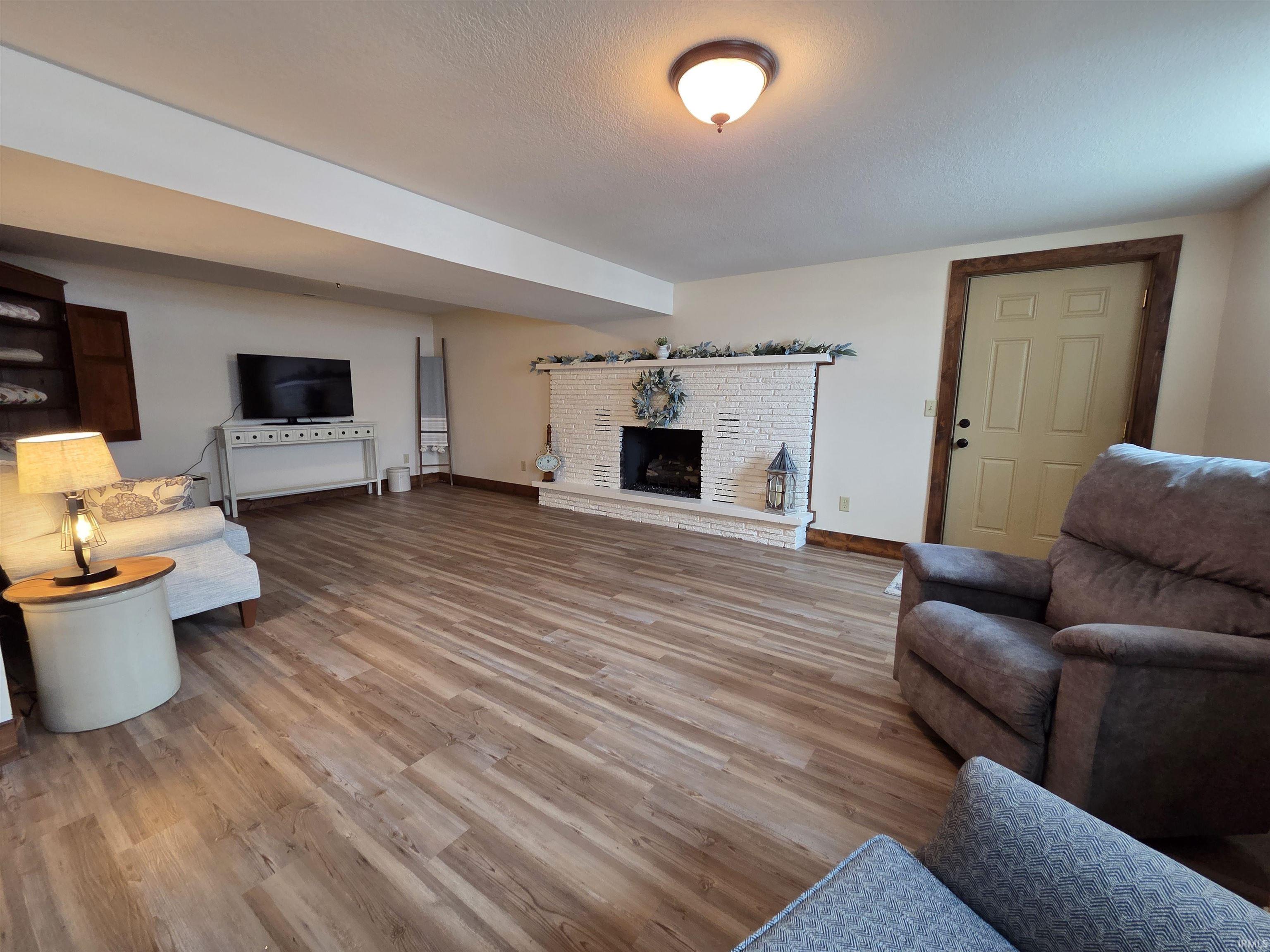Living area featuring light wood-style floors and a textured ceiling
