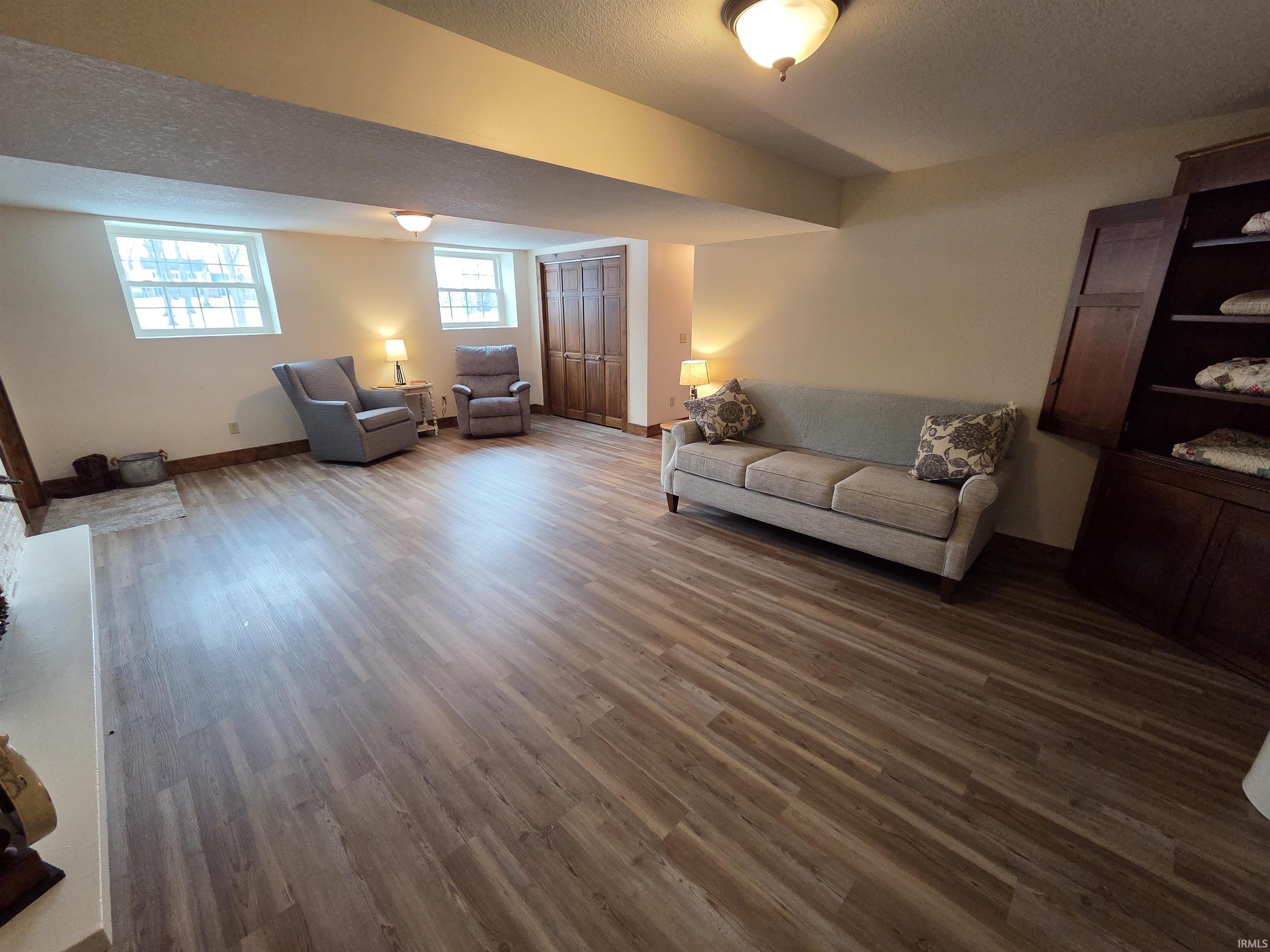 Living area featuring wood finished floors and a textured ceiling