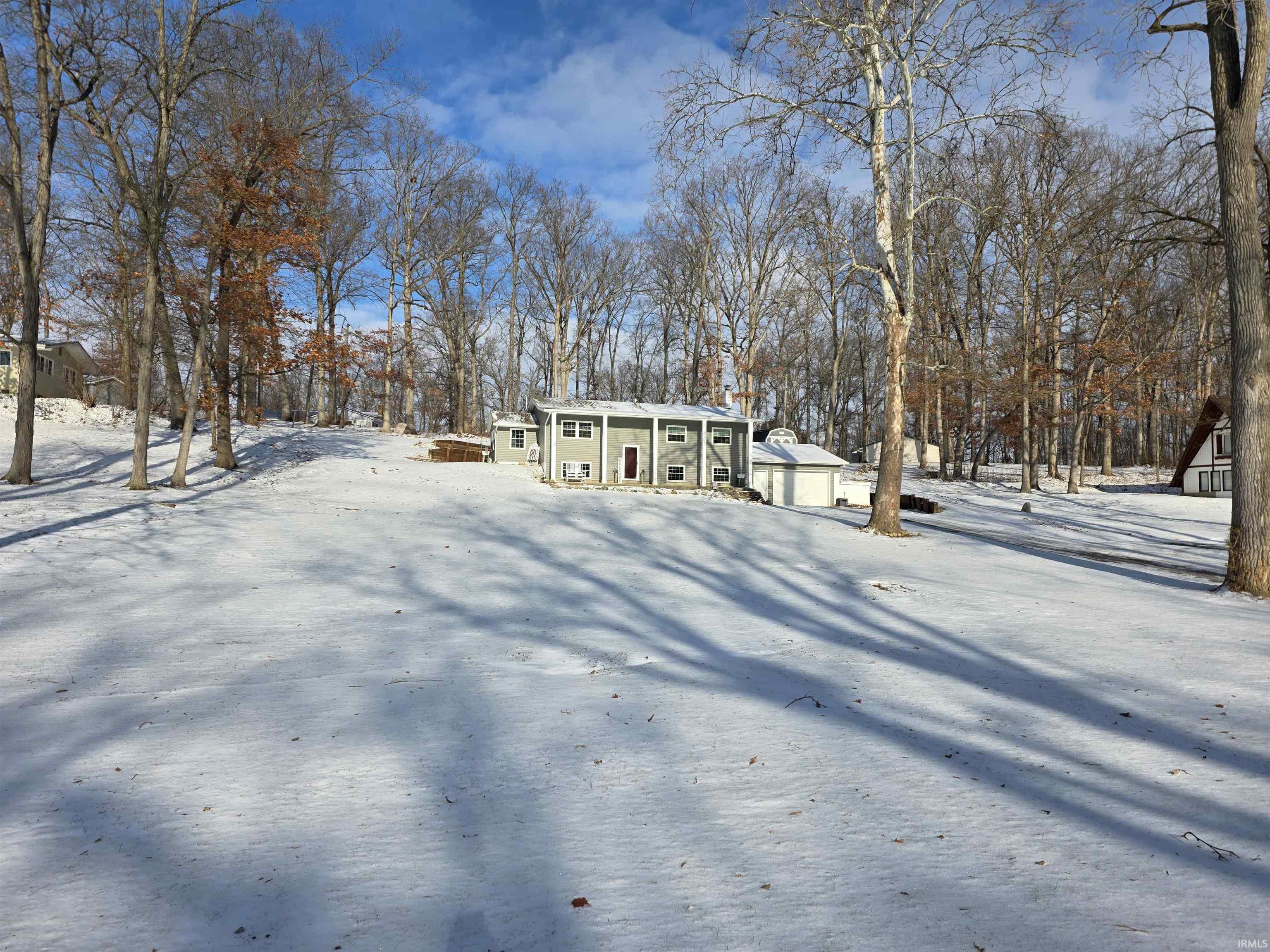 View of front of property with covered porch and view of scattered trees