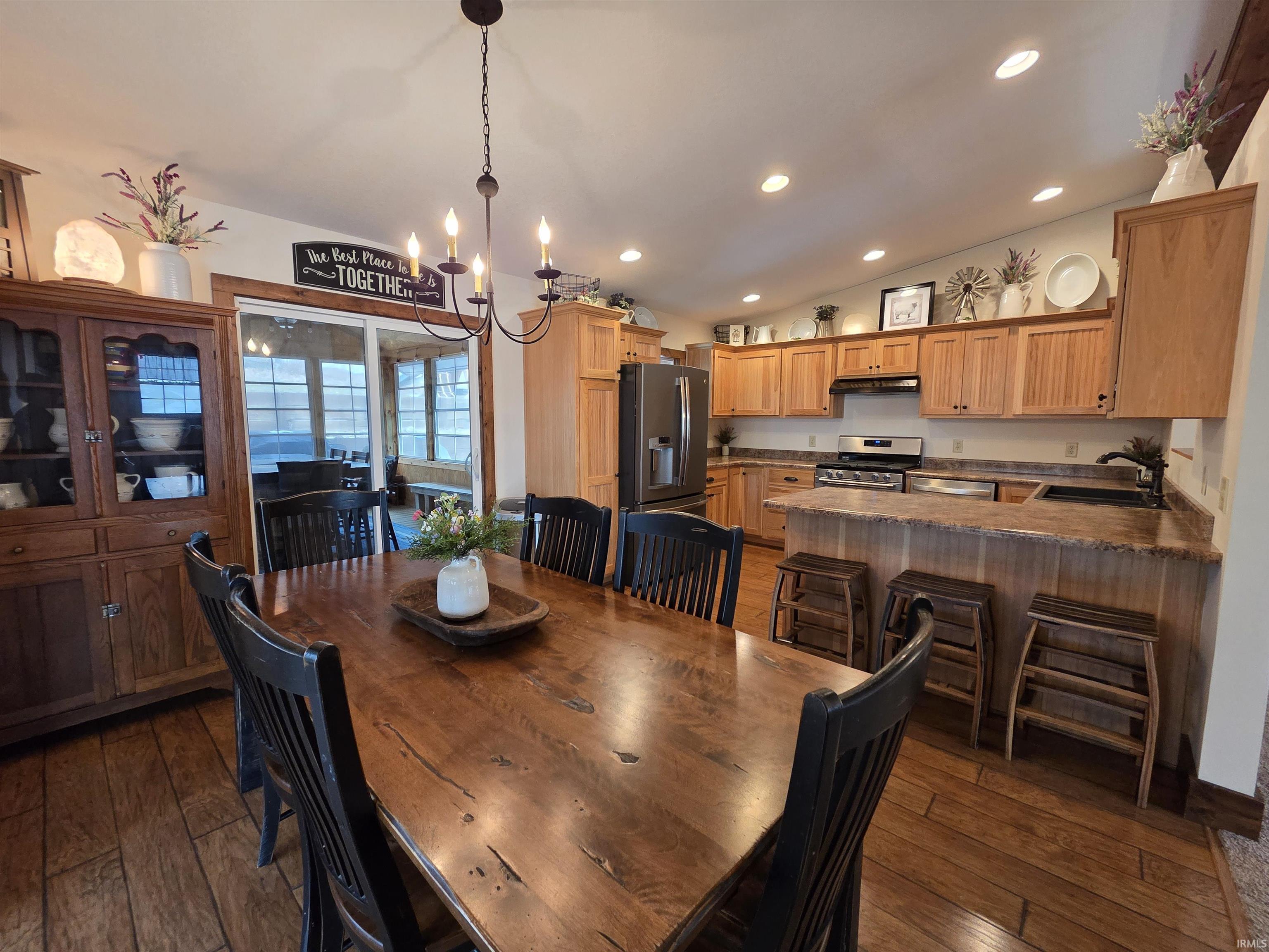 Dining area featuring lofted ceiling, hanging lights, and dark wood-style floors