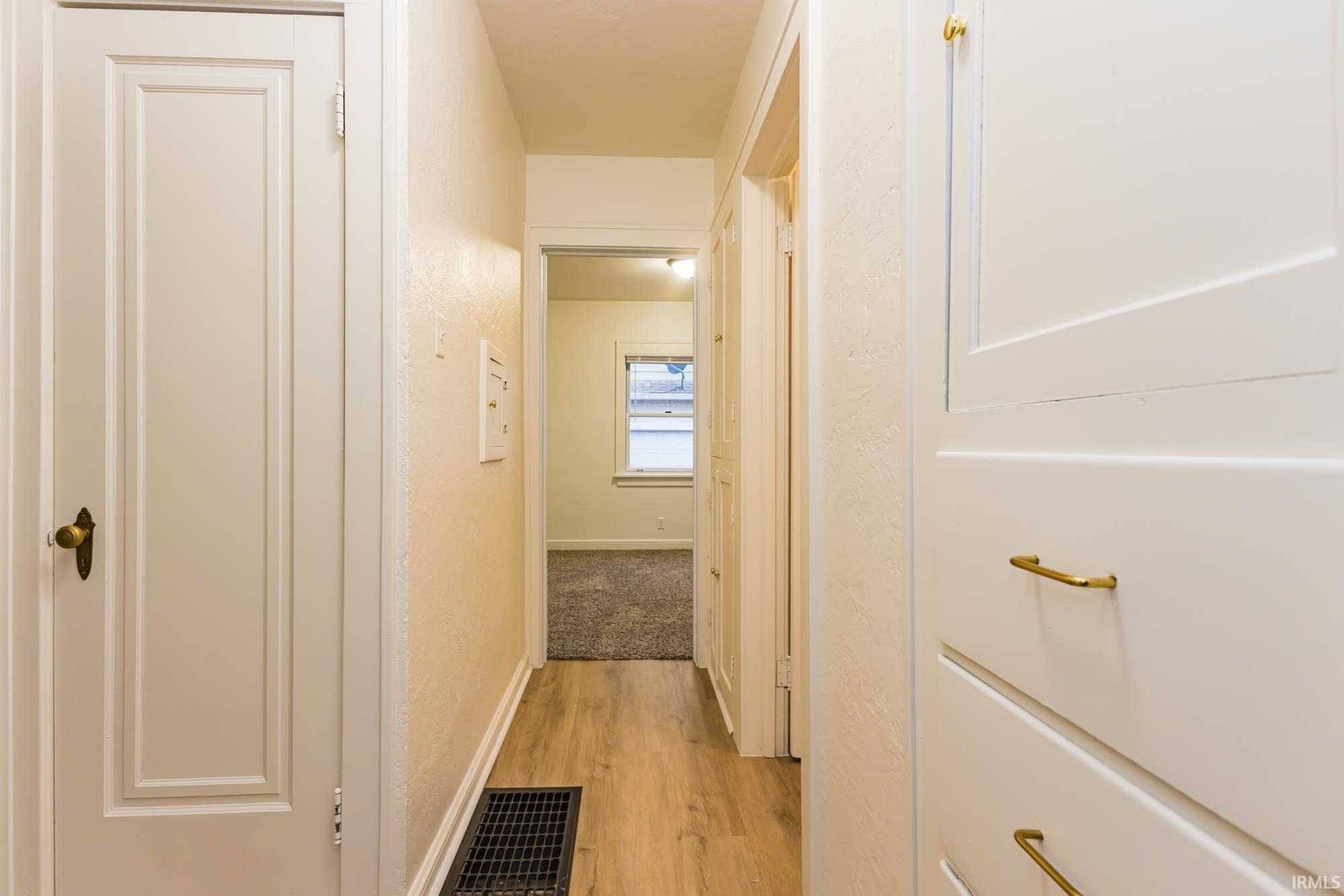 Corridor with light wood-style floors and baseboards