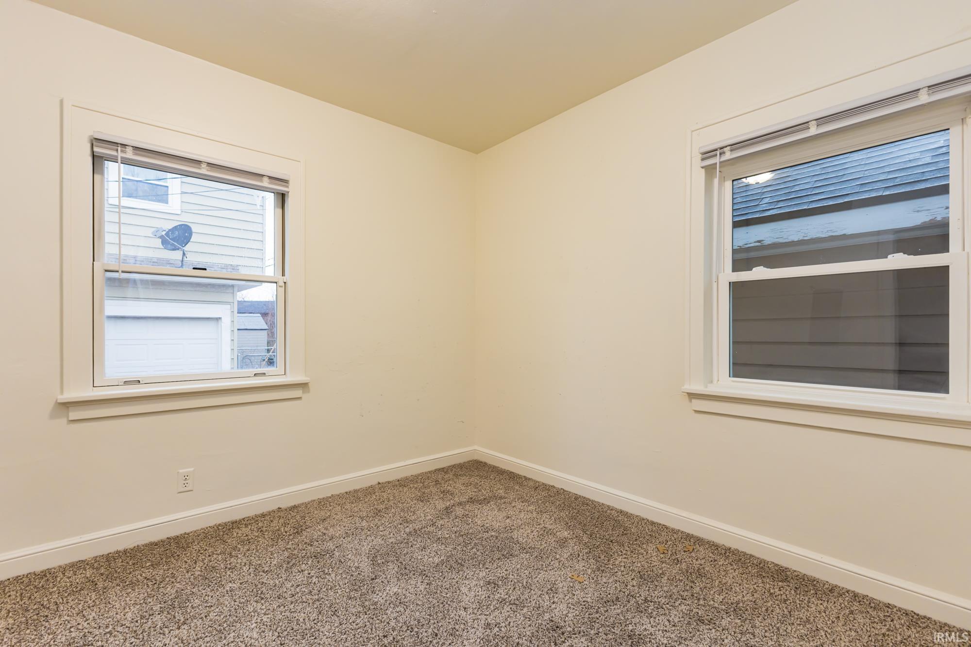 Carpeted empty room with baseboards