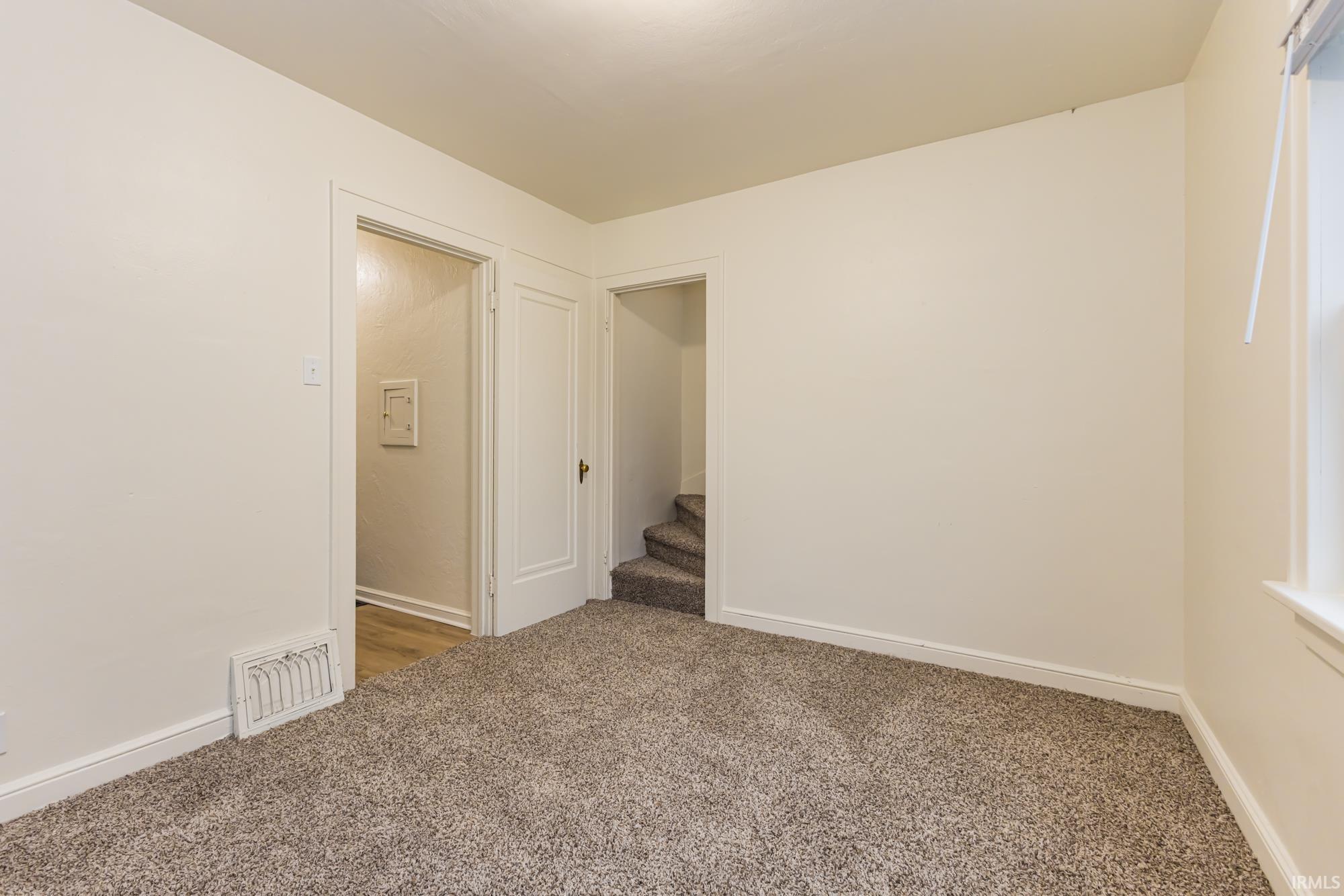 Empty room featuring carpet flooring and baseboards