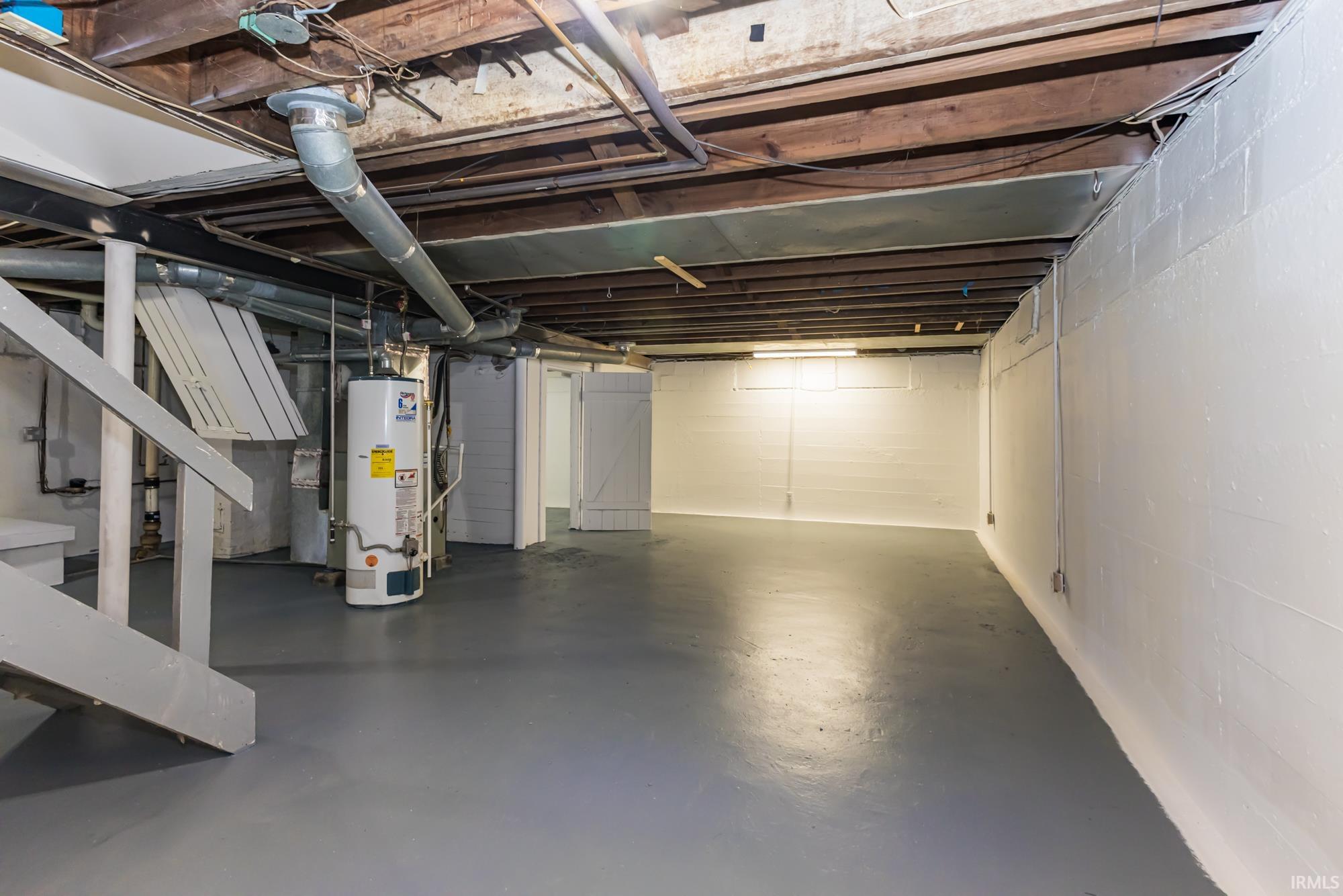 Unfinished below grade area featuring water heater