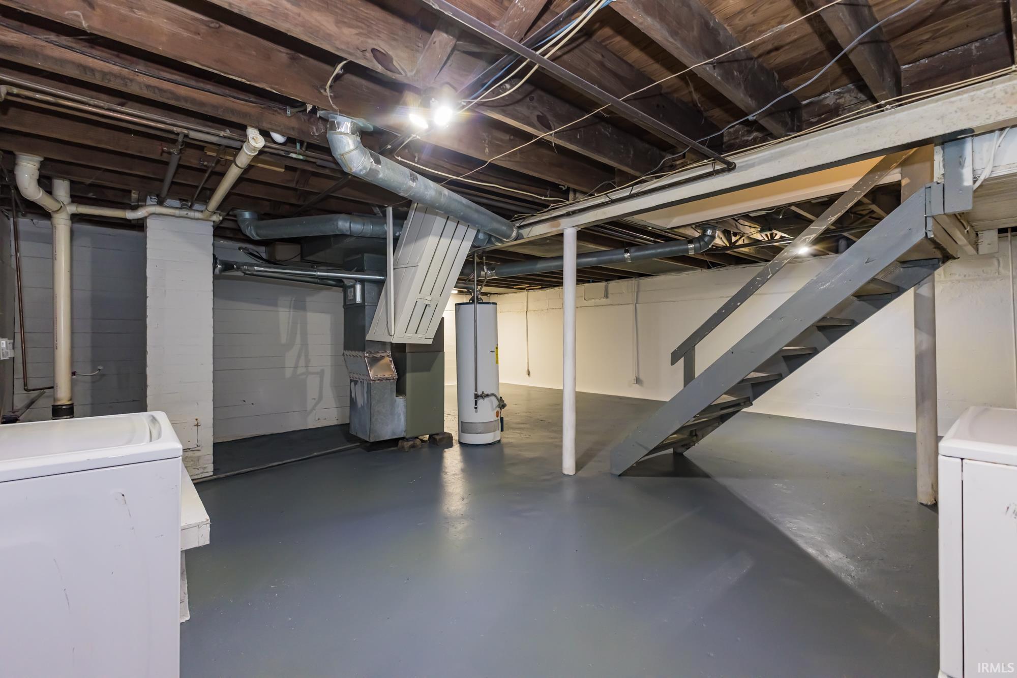 Unfinished below grade area with stairway and water heater