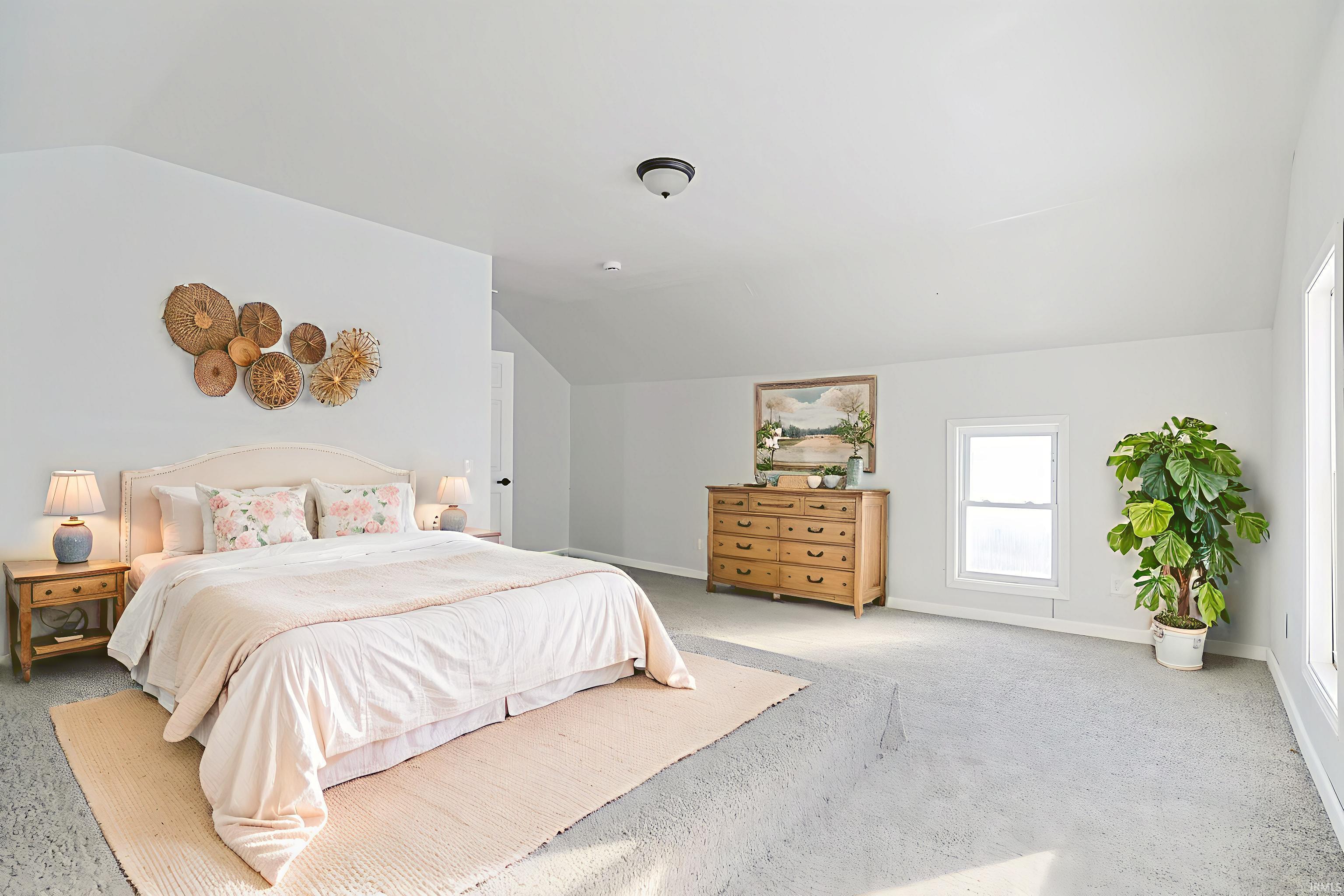 Bedroom with lofted ceiling and carpet