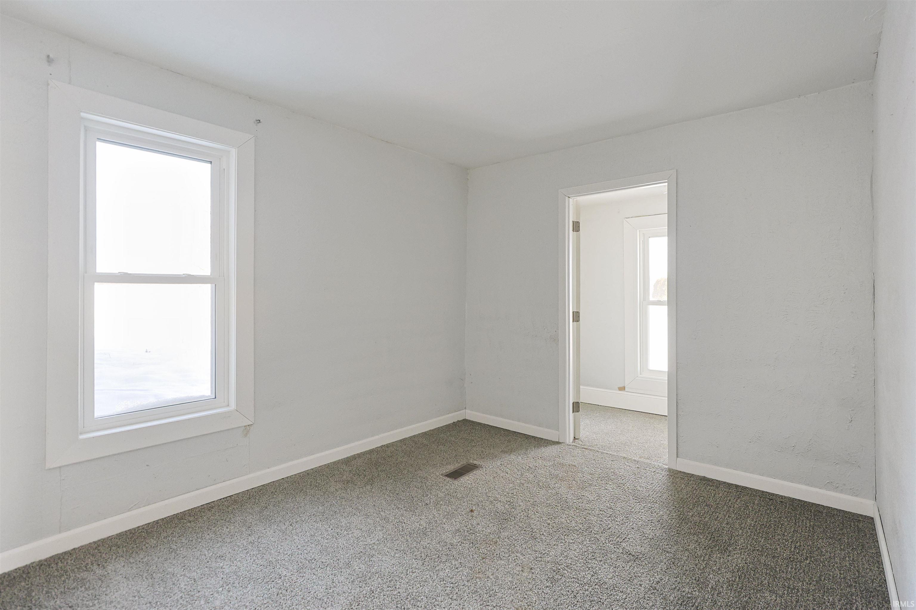 Carpeted empty room featuring baseboards