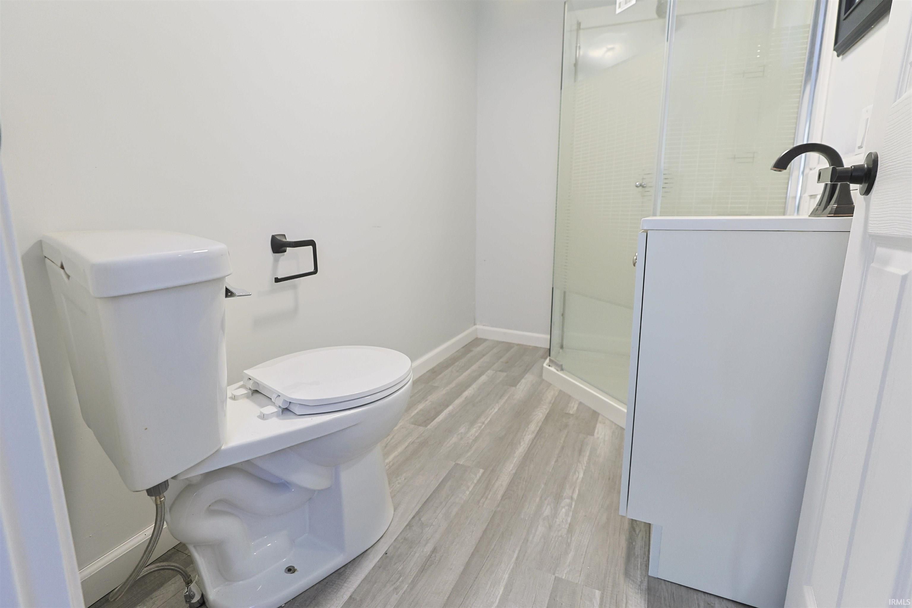 Bathroom featuring a stall shower and light wood-type flooring