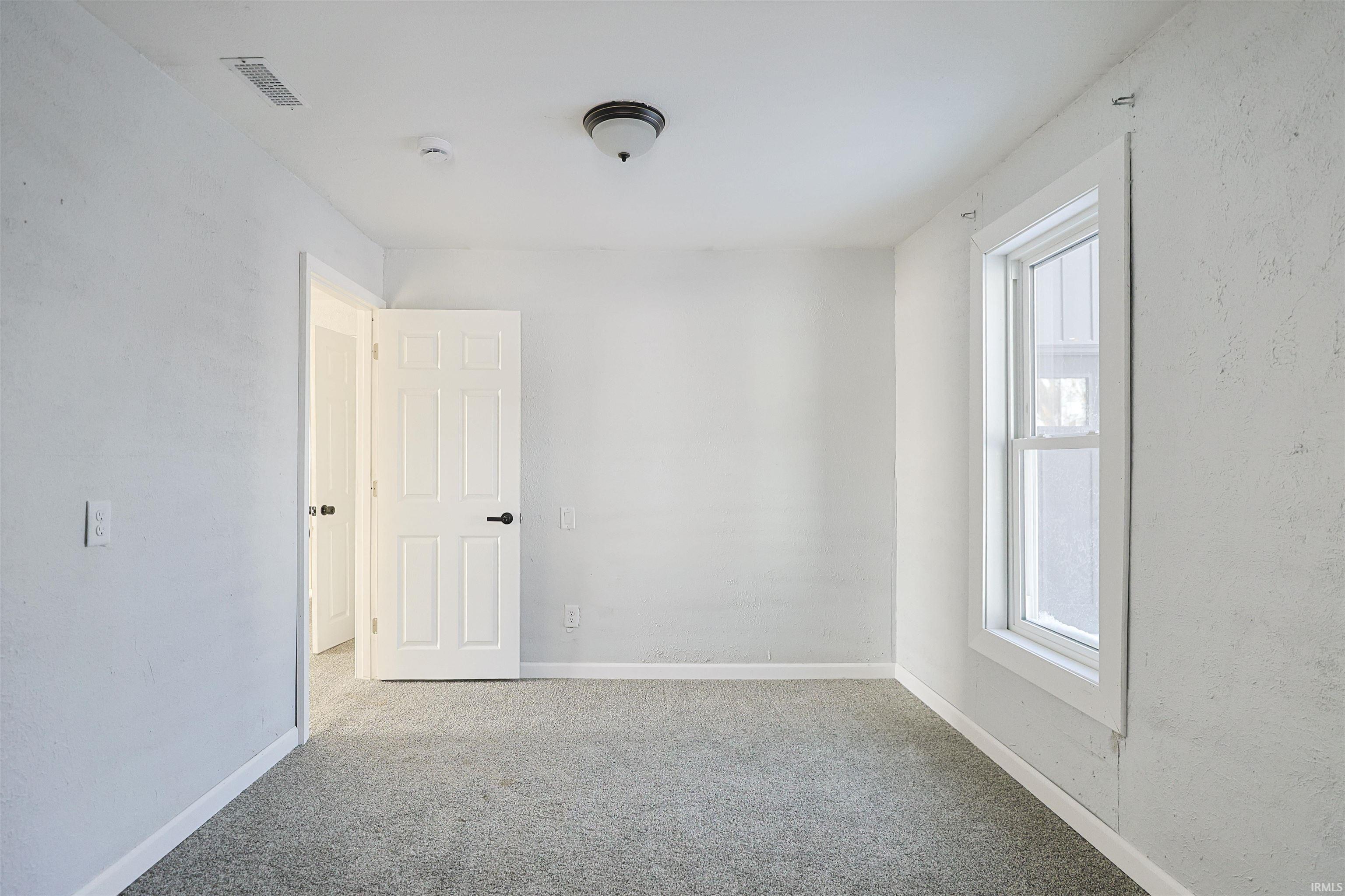 Carpeted empty room with baseboards