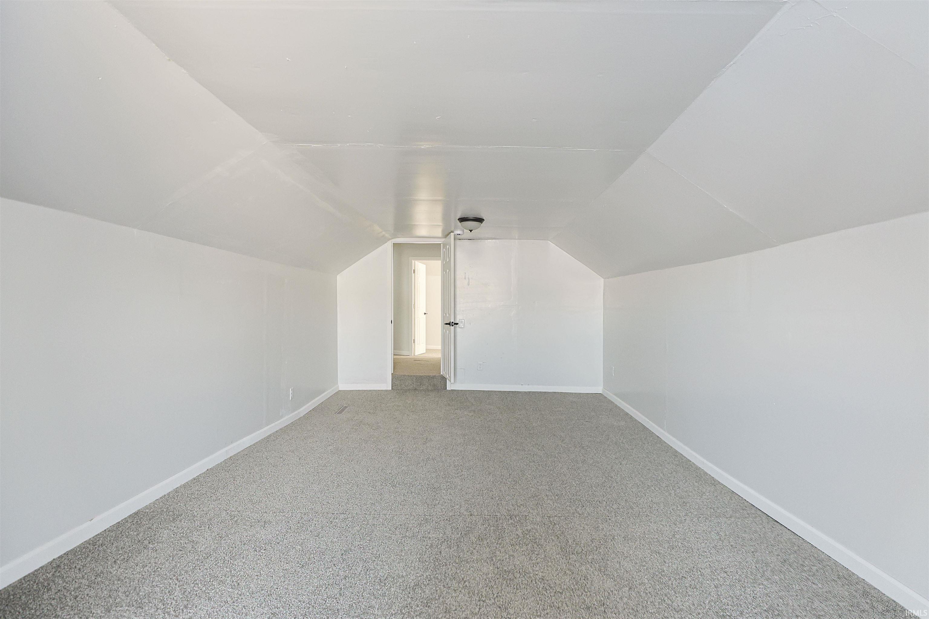 Bonus room featuring lofted ceiling and carpet