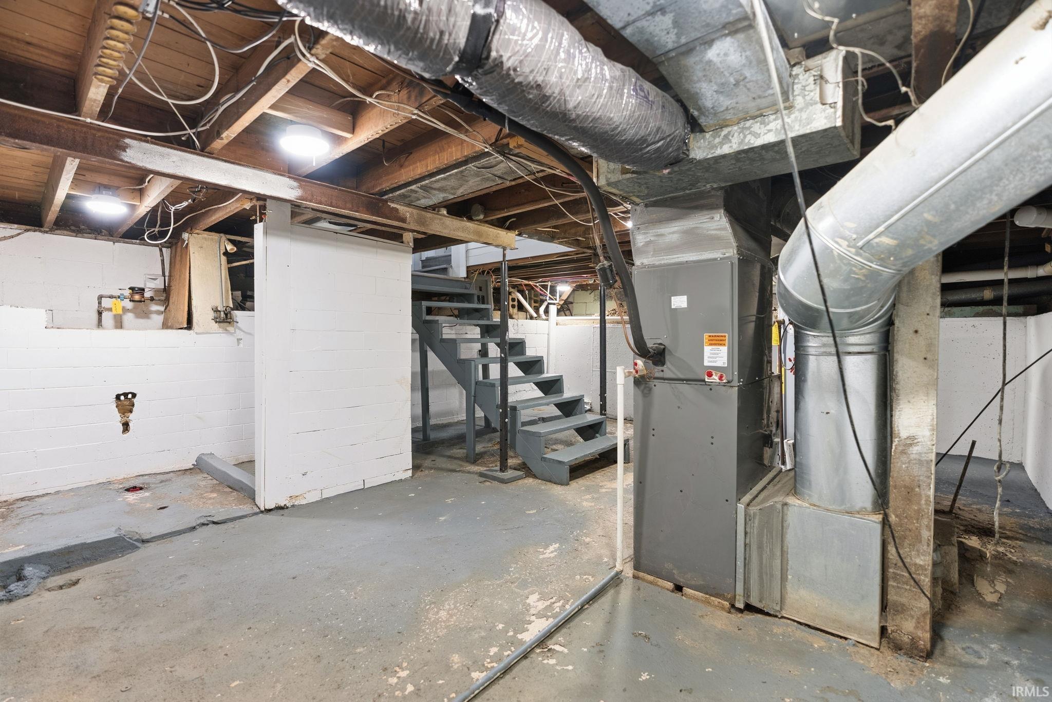 Unfinished below grade area with stairway and heating unit