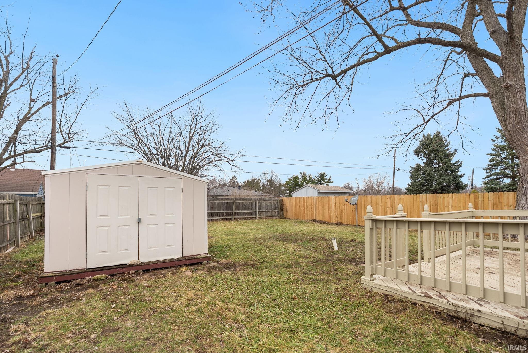 Fenced backyard with a deck and a shed