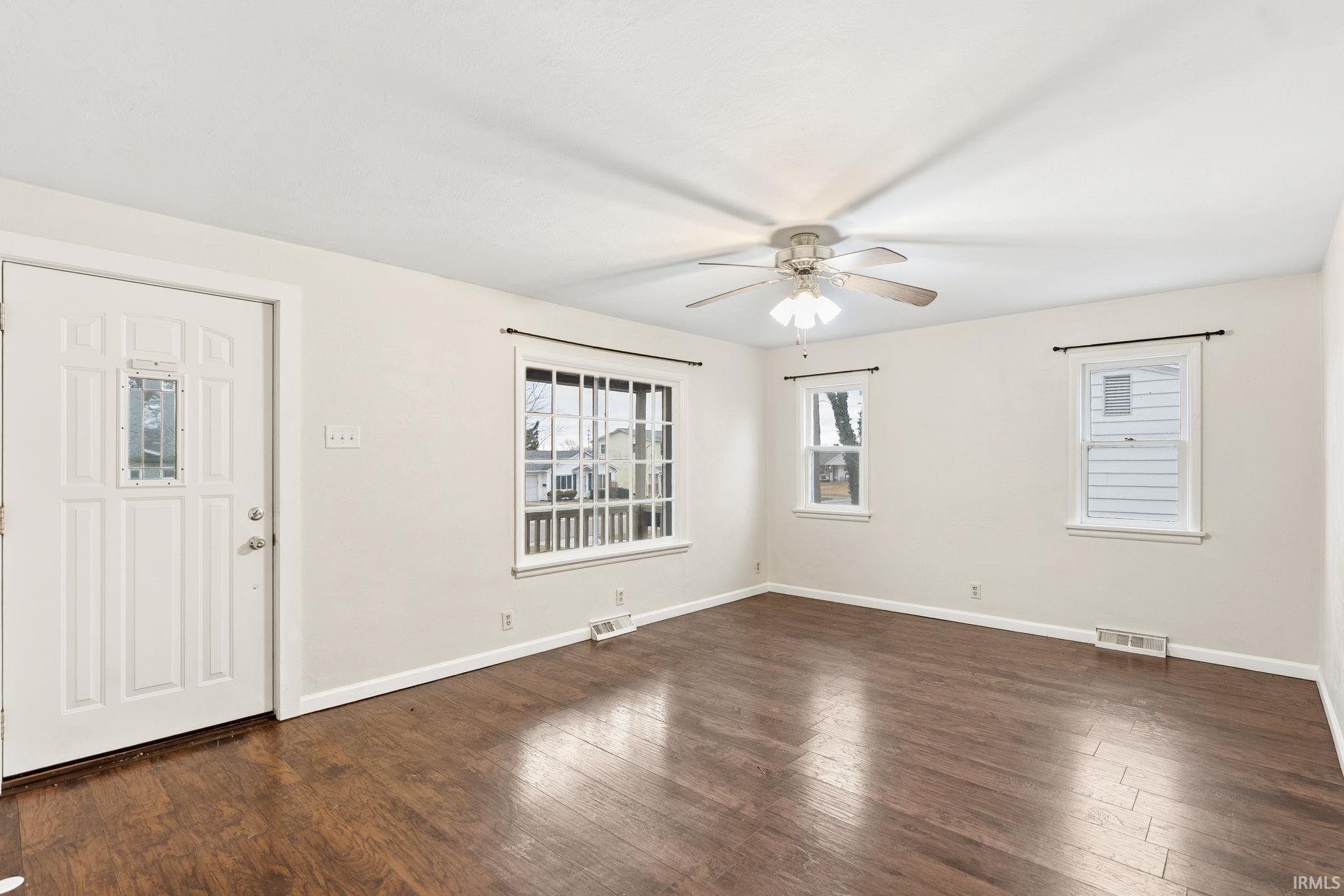Entryway with dark wood finished floors and a ceiling fan