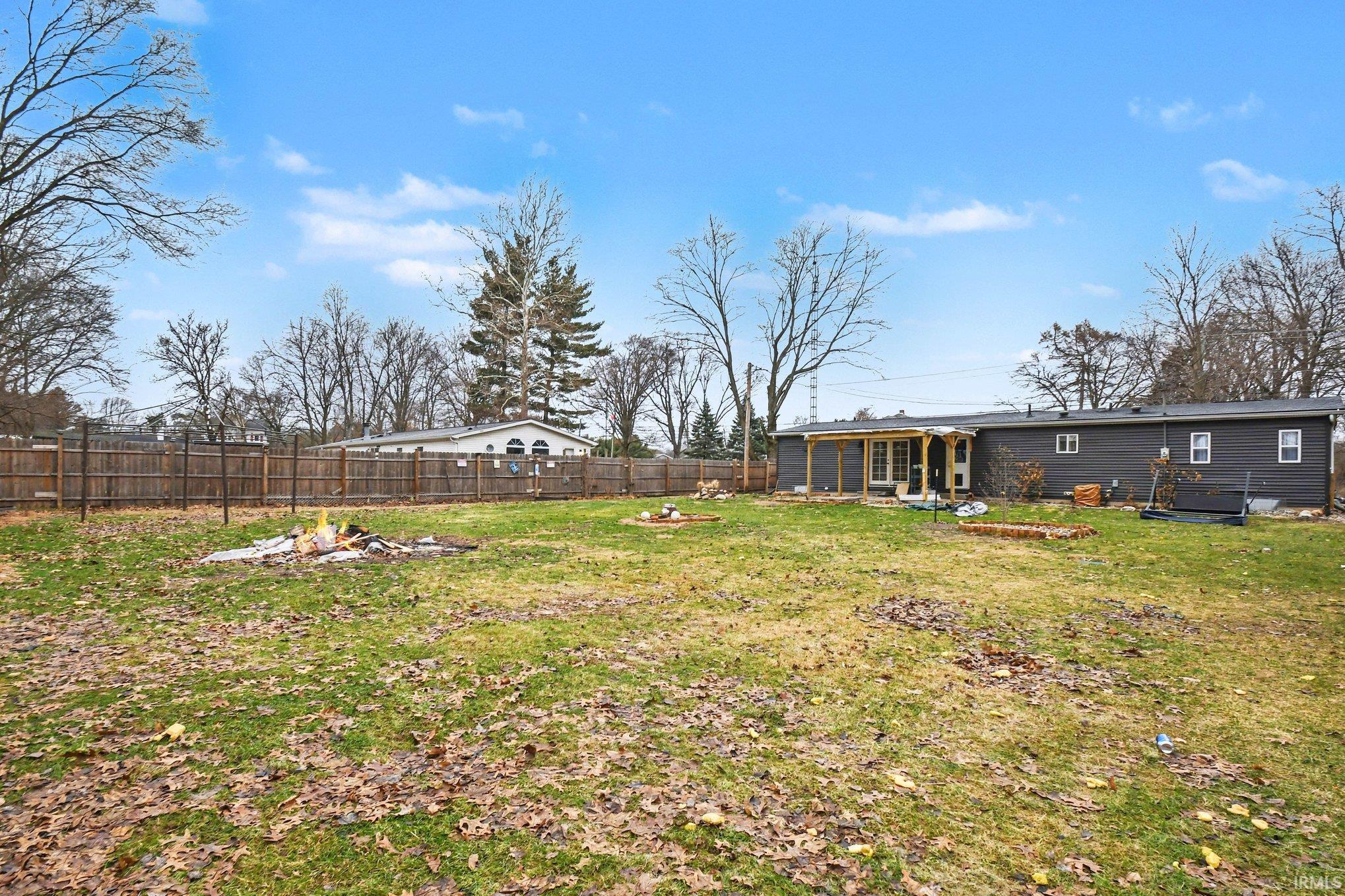 Fenced backyard with an outdoor fire pit
