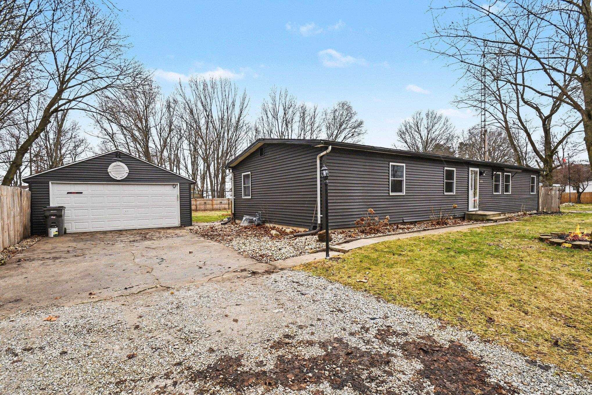 View of front of house with an outbuilding and a garage