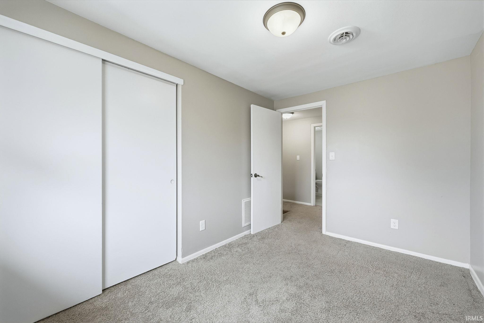 Unfurnished bedroom featuring carpet flooring and a closet