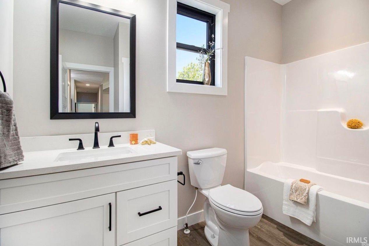 Bathroom featuring vanity, dark wood-type flooring, and bathing tub / shower combination