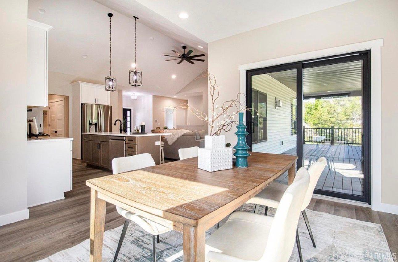 Dining space featuring dark wood-type flooring, vaulted ceiling, ceiling fan, and recessed lighting