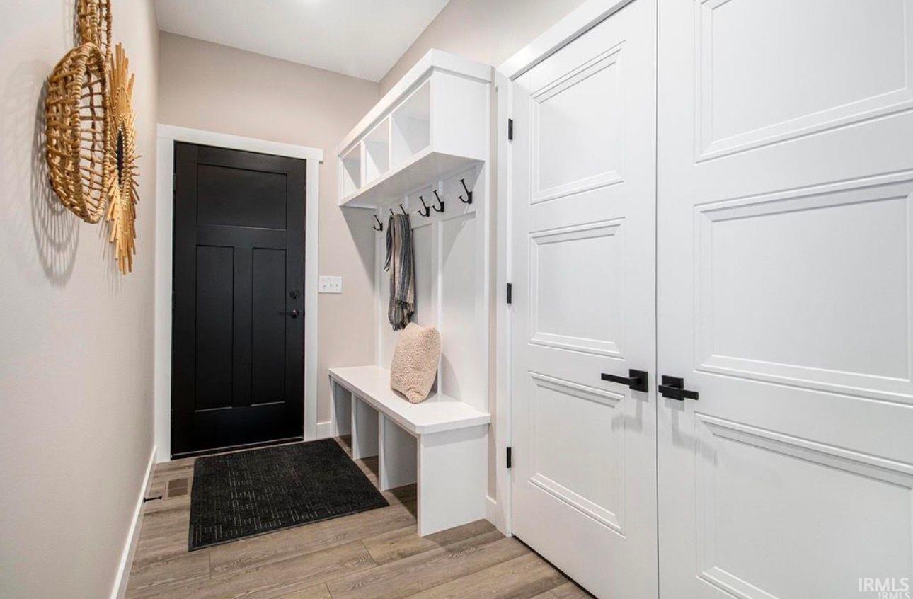 Mudroom with light wood finished floors and baseboards