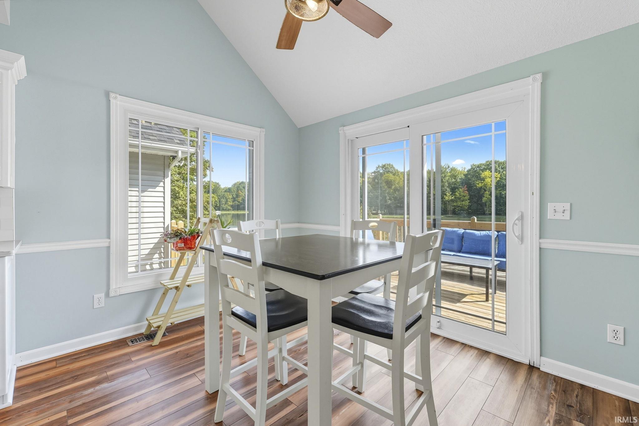 Dining space with a ceiling fan, dark wood finished floors, and lofted ceiling