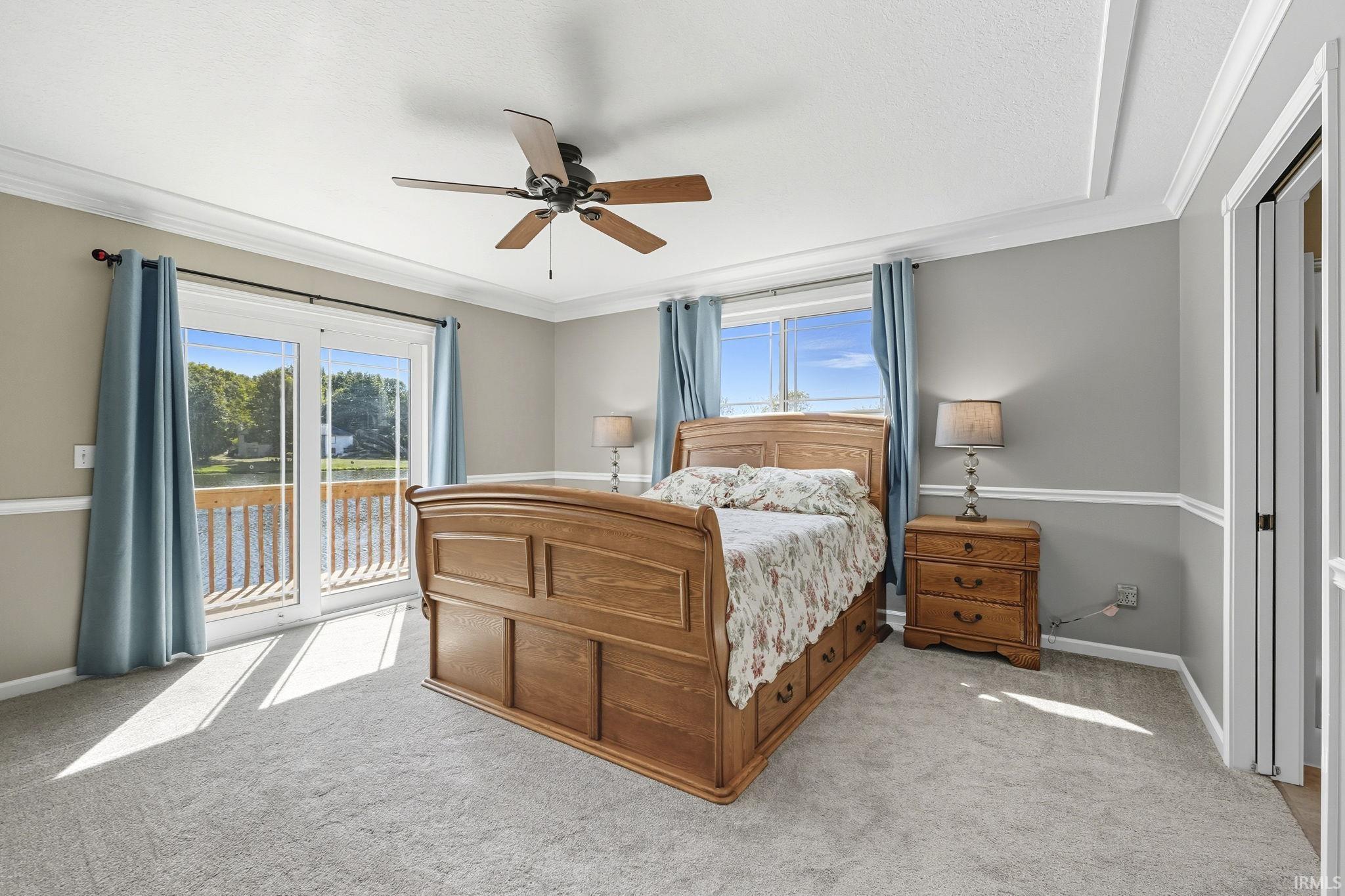 Carpeted bedroom with access to exterior, a ceiling fan, and crown molding