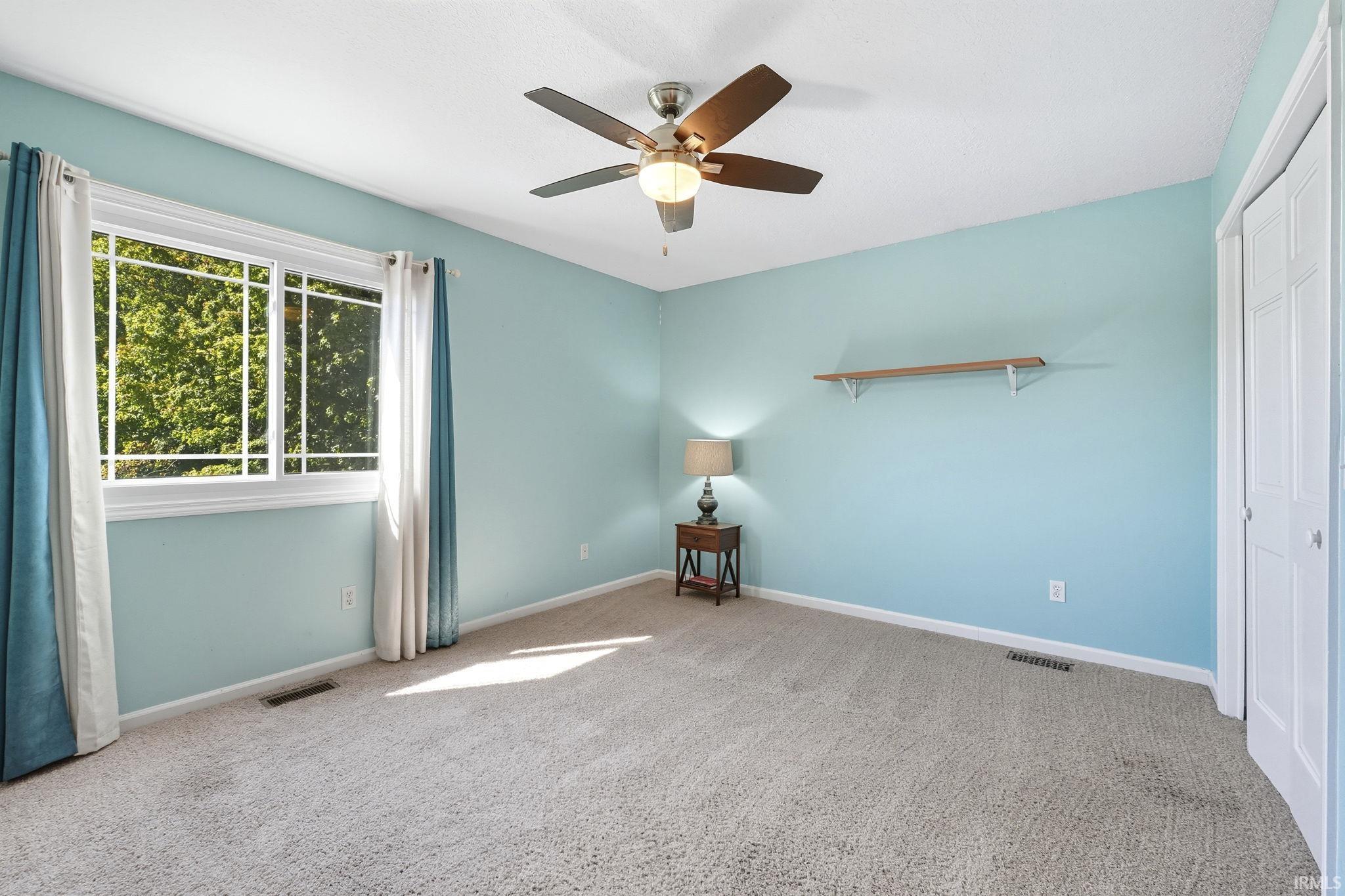 Unfurnished bedroom with a closet, ceiling fan, and light carpet