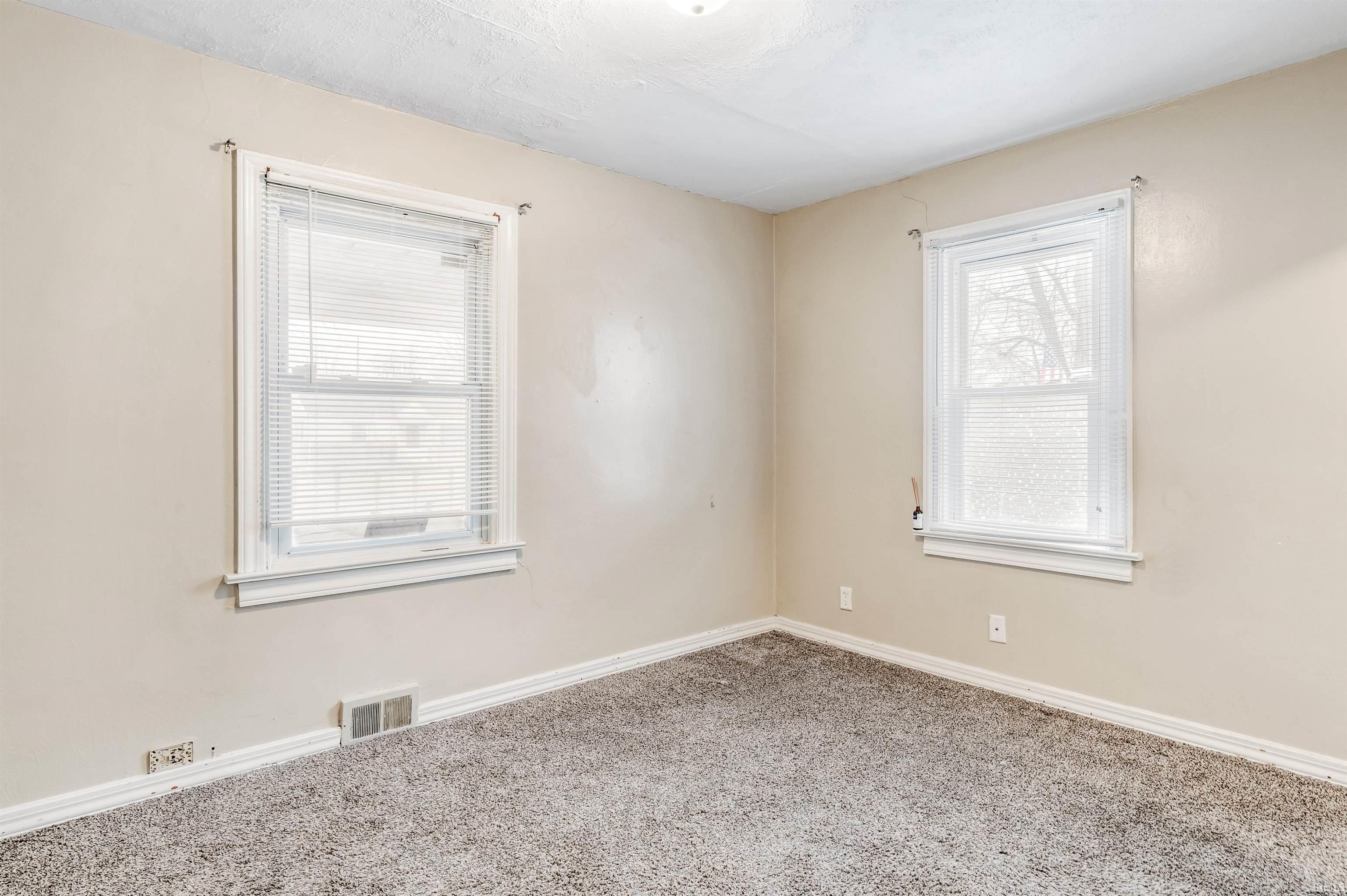 Empty room with carpet floors and baseboards