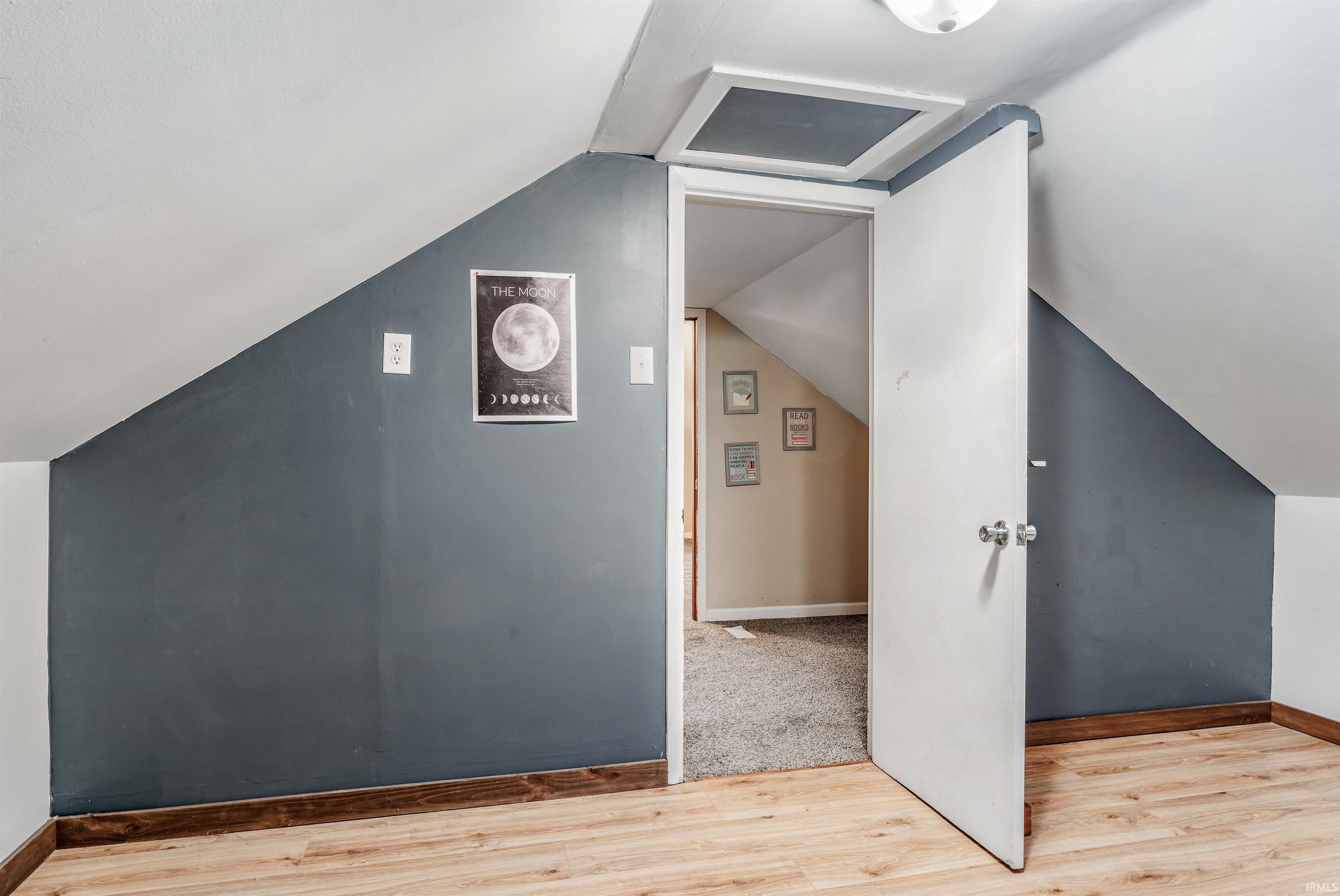Bonus room featuring light wood-style floors and lofted ceiling