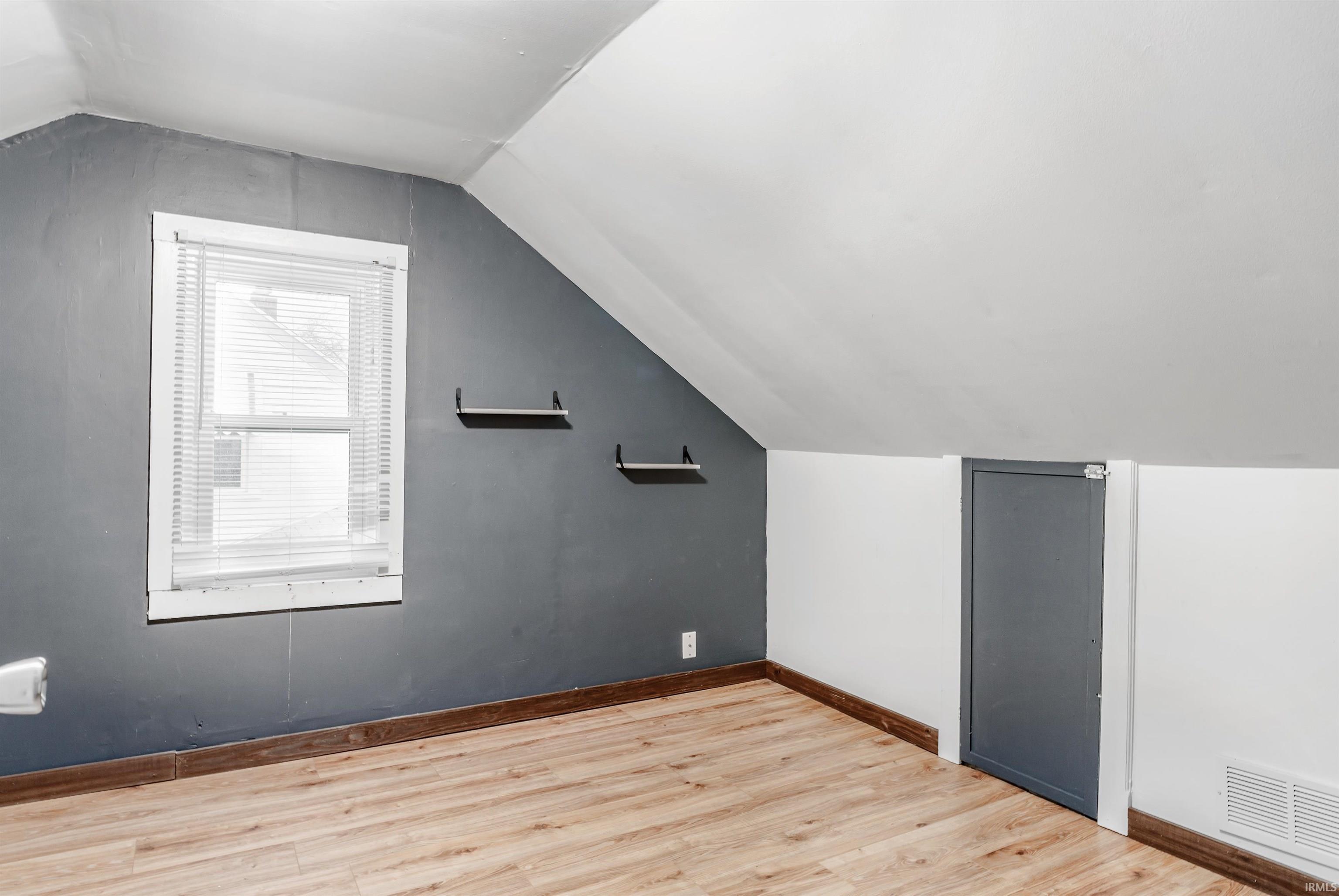Additional living space with light wood-style flooring and baseboards