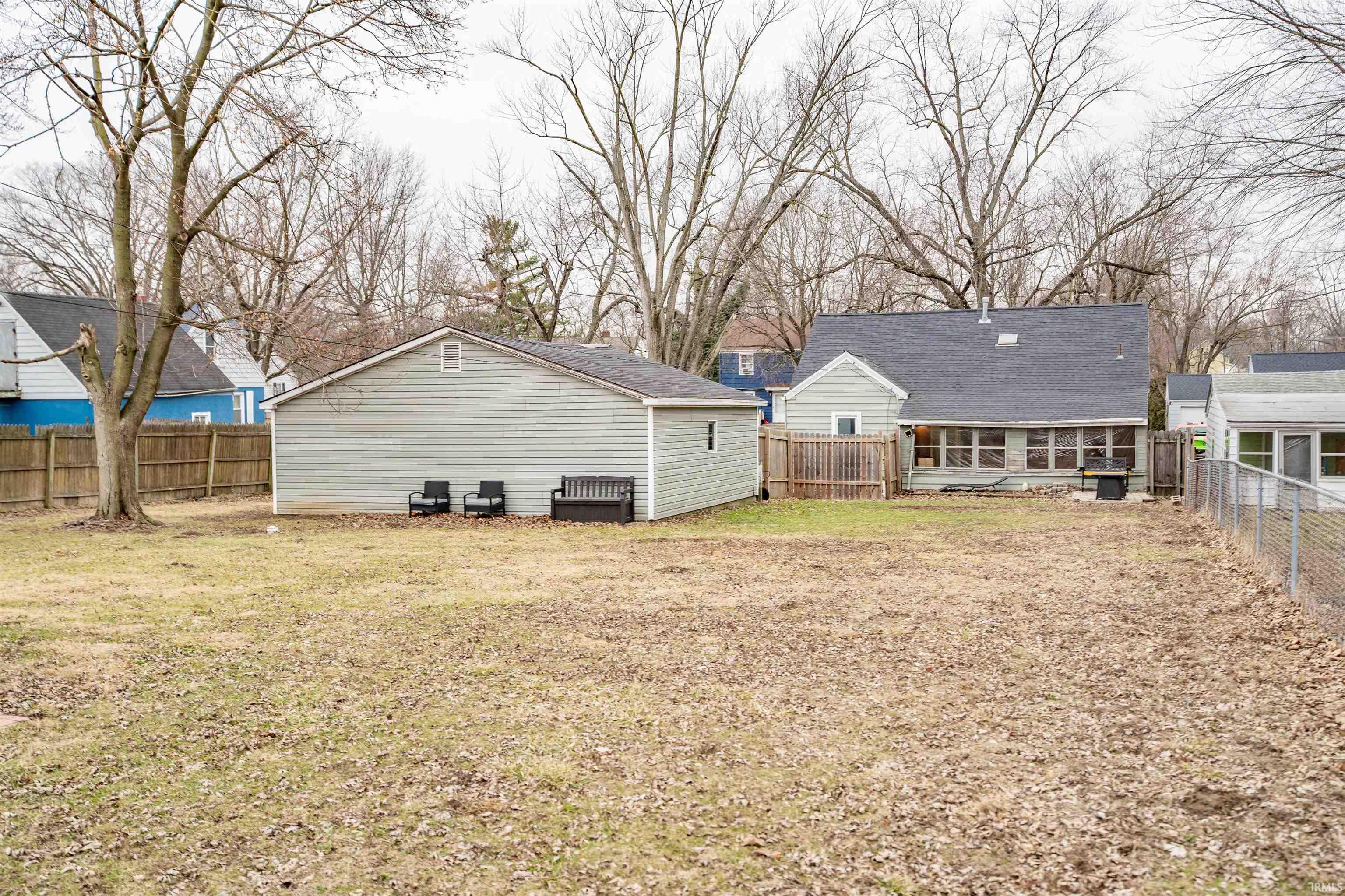 Rear view of property with a fenced backyard and a sunroom