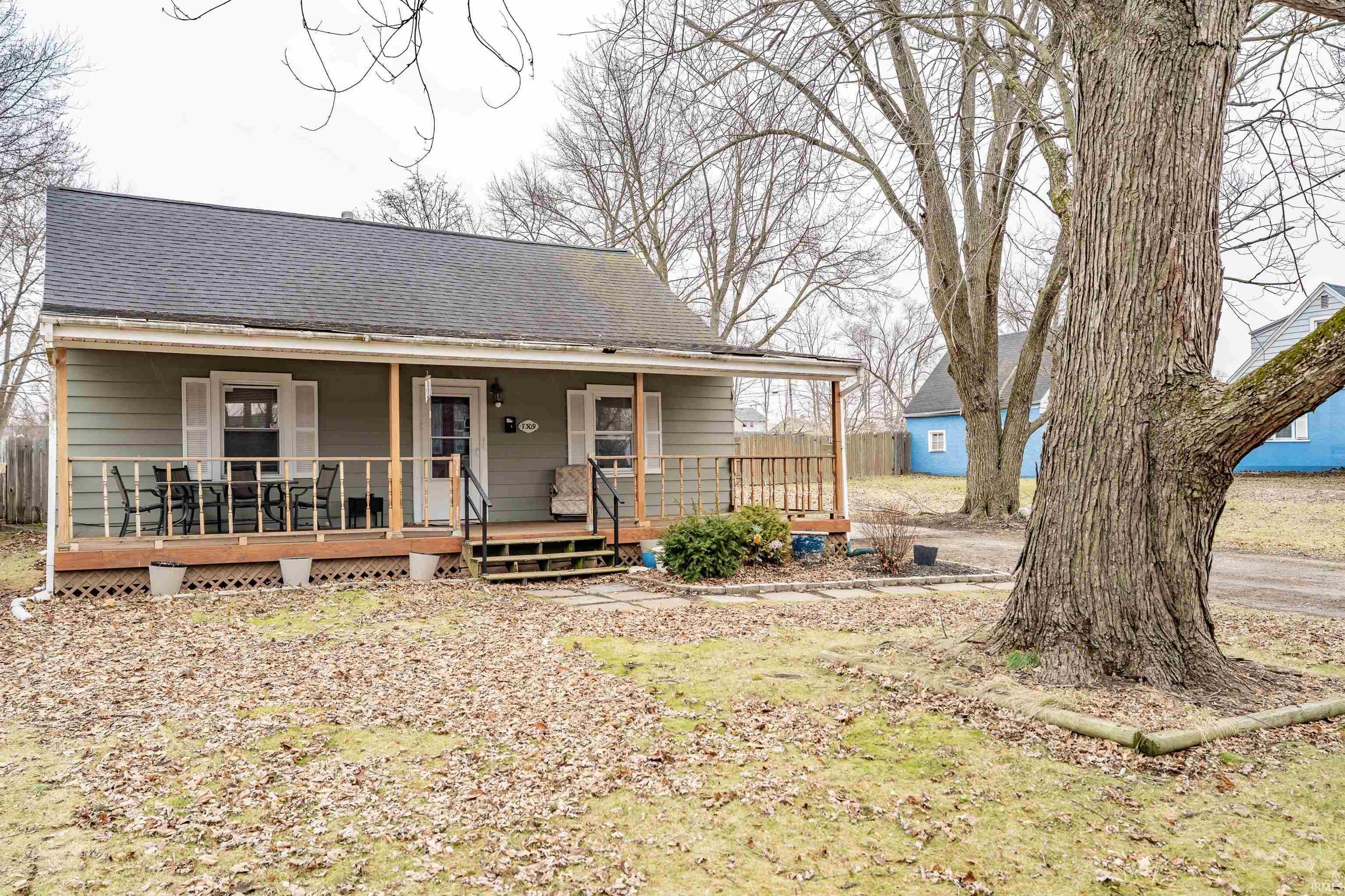 View of front of home featuring covered porch and a shingled roof