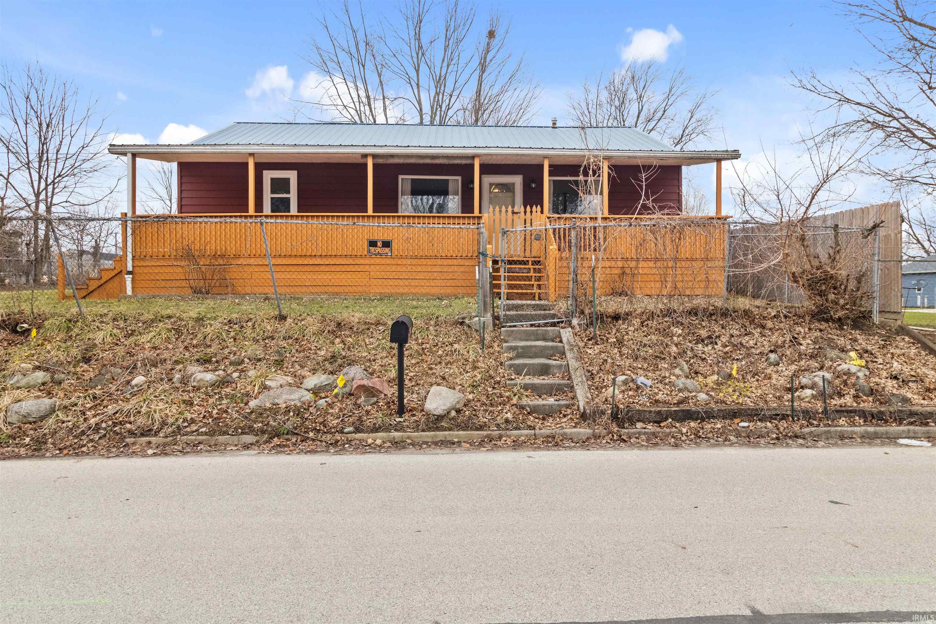 View of front of house featuring covered porch and a metal roof