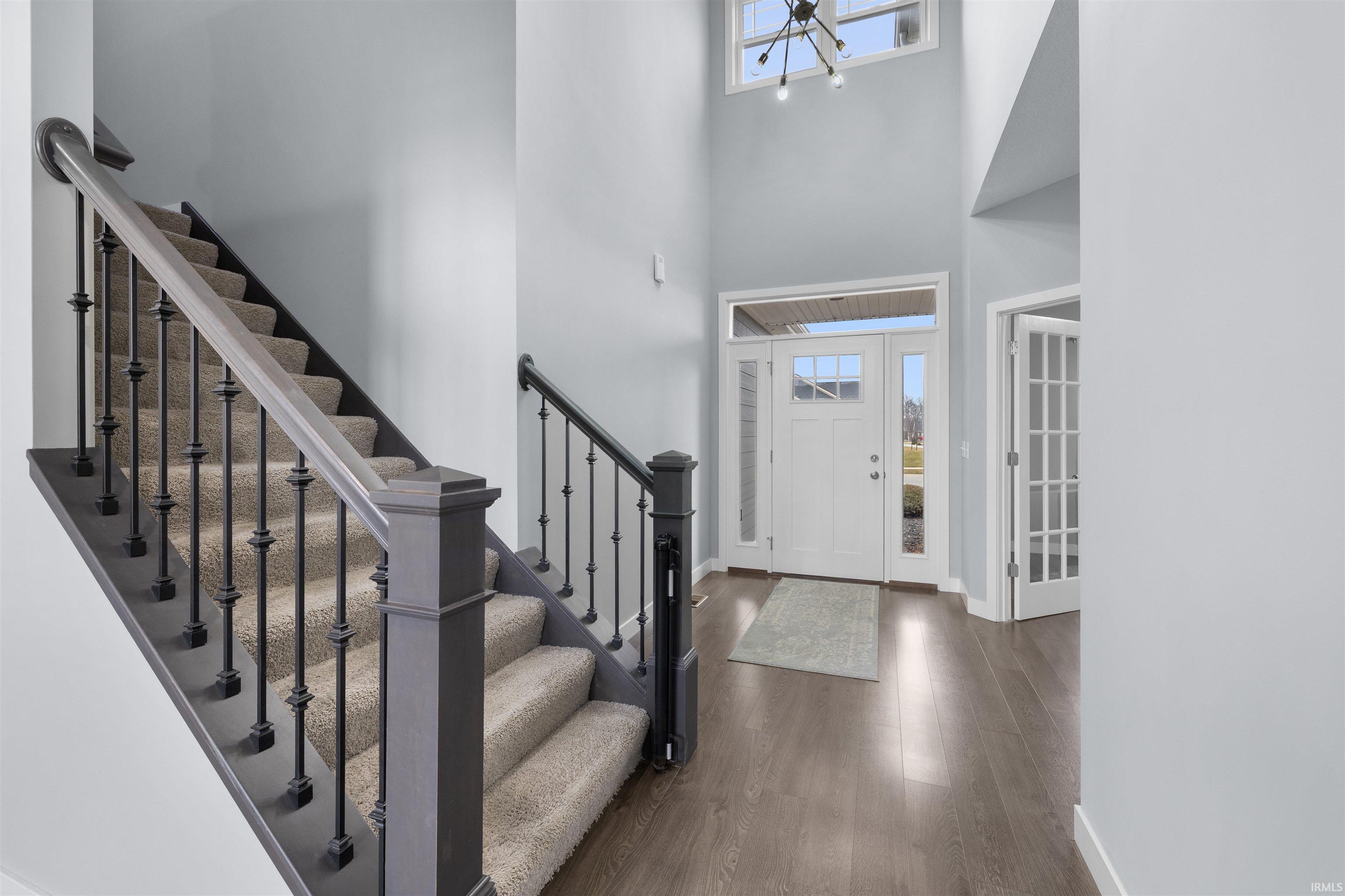 Entrance foyer featuring dark wood-style flooring and a high ceiling