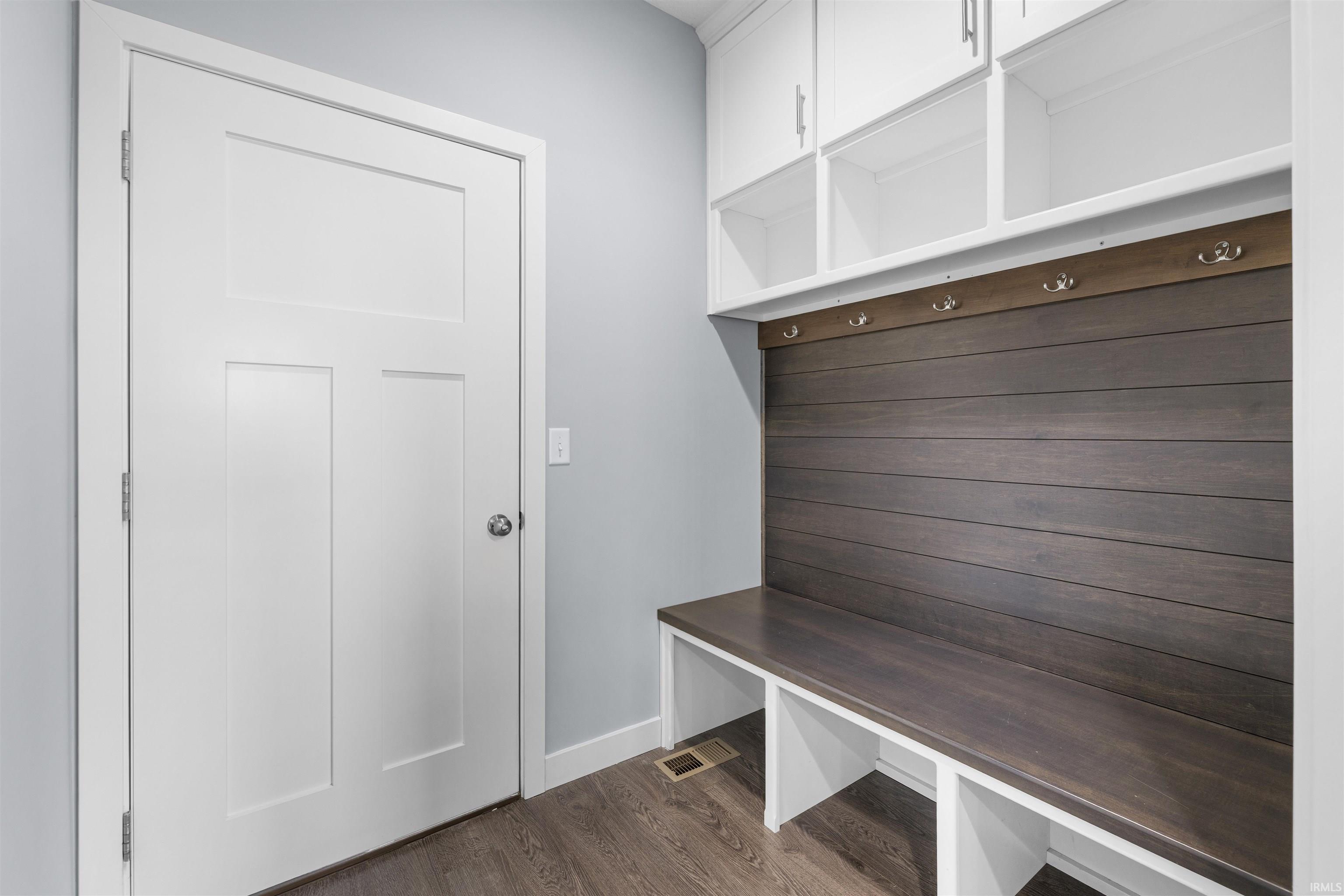 Mudroom featuring dark wood-style flooring and baseboards