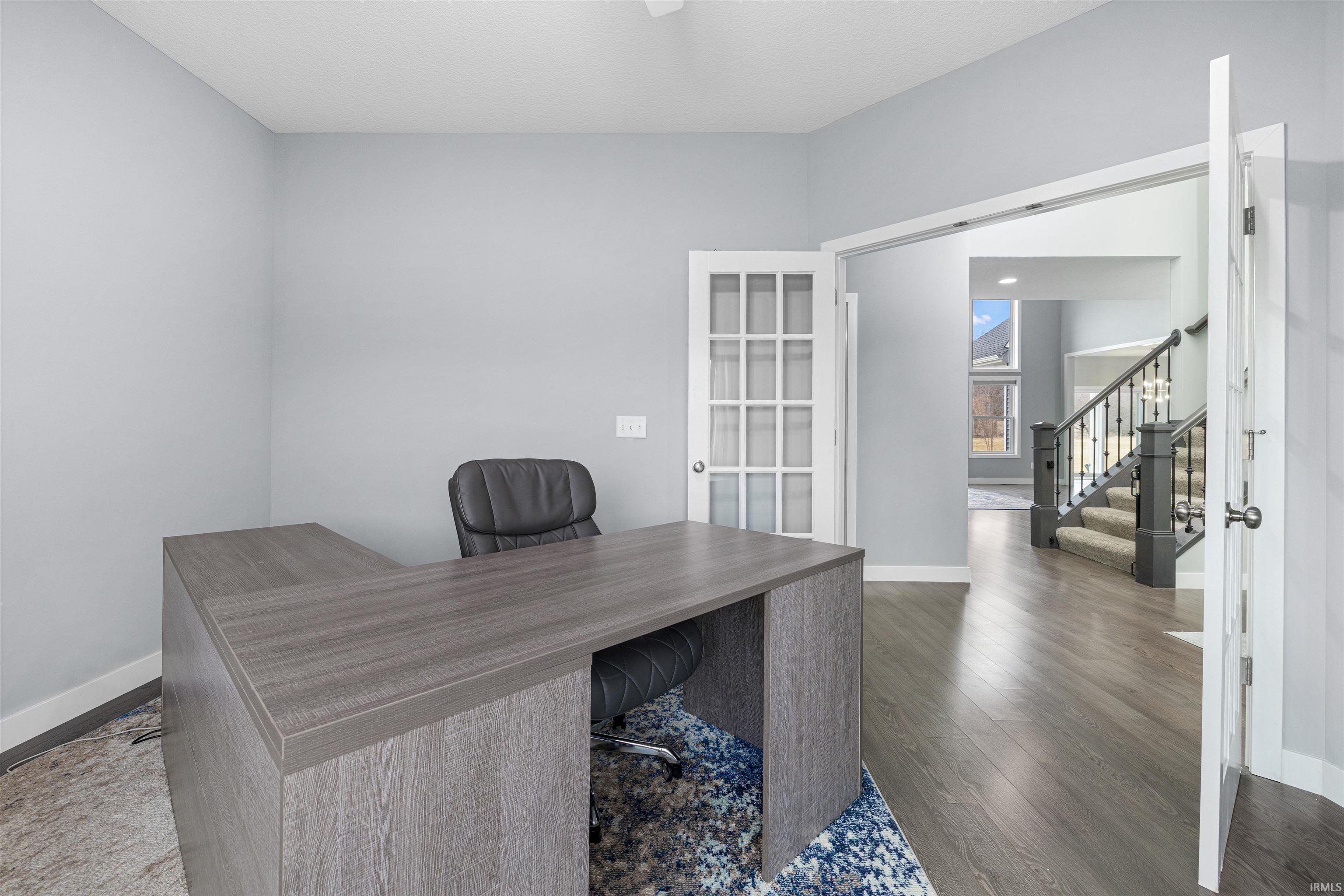Office space featuring dark wood-type flooring and baseboards