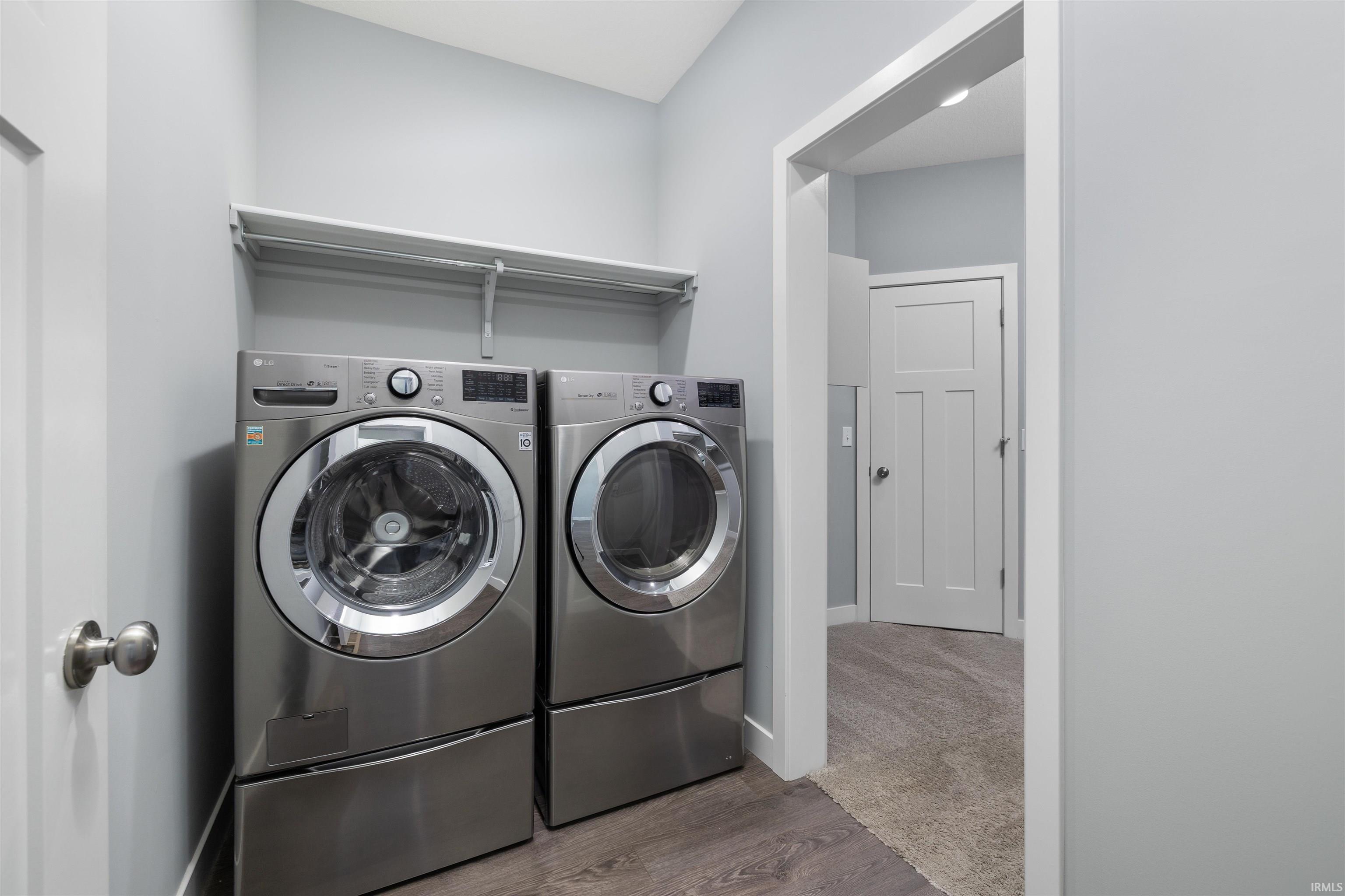 Laundry room featuring wood finished floors and independent washer and dryer