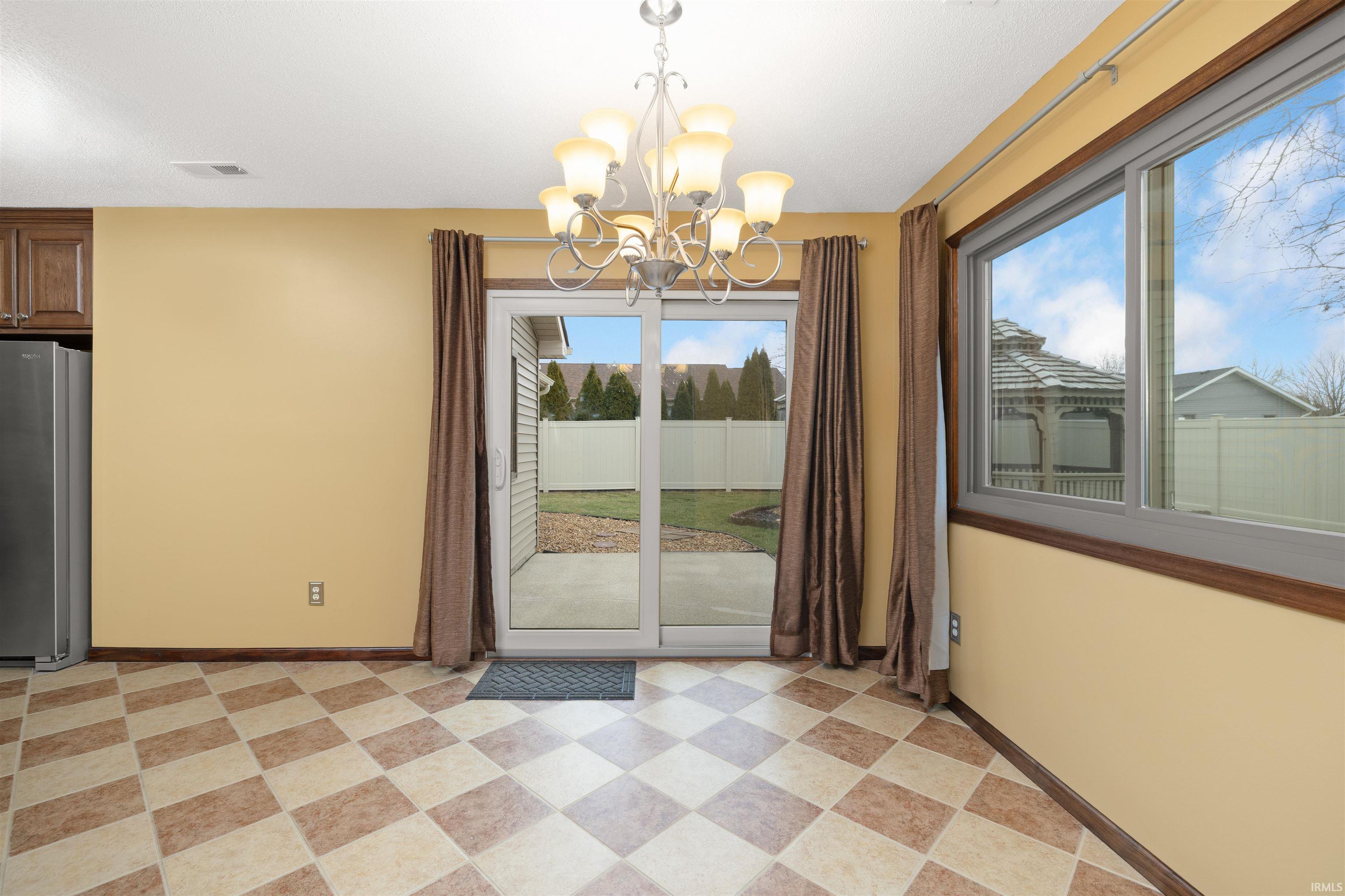 Unfurnished dining area with suspended lighting and light floors