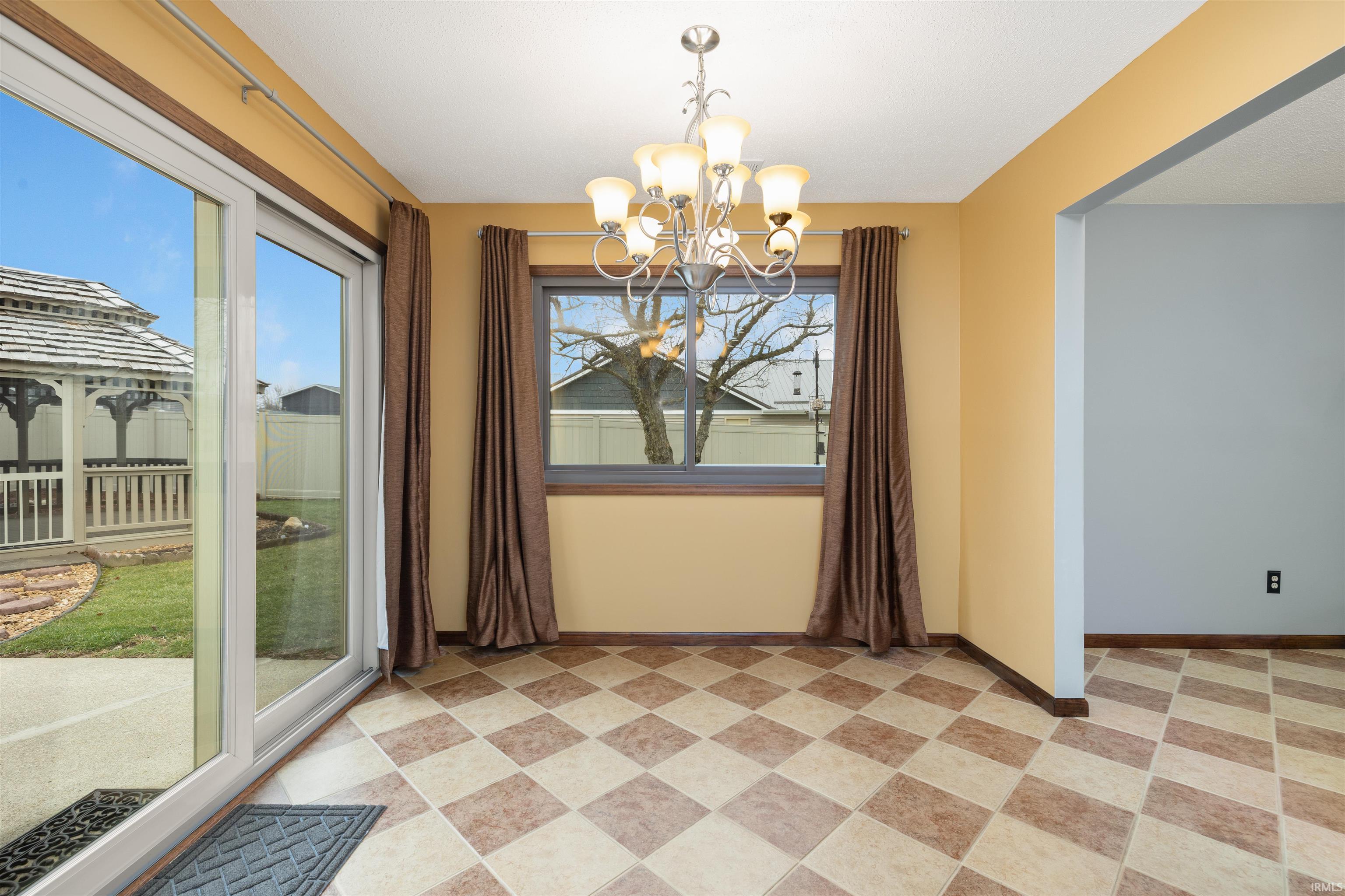 Unfurnished dining area featuring a chandelier and baseboards