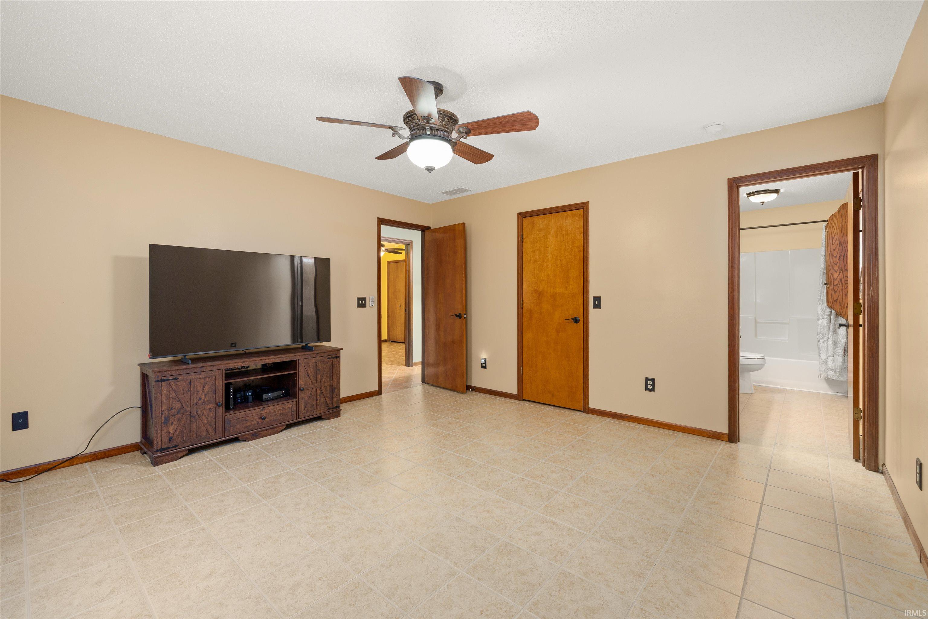 Unfurnished living room with ceiling fan and baseboards