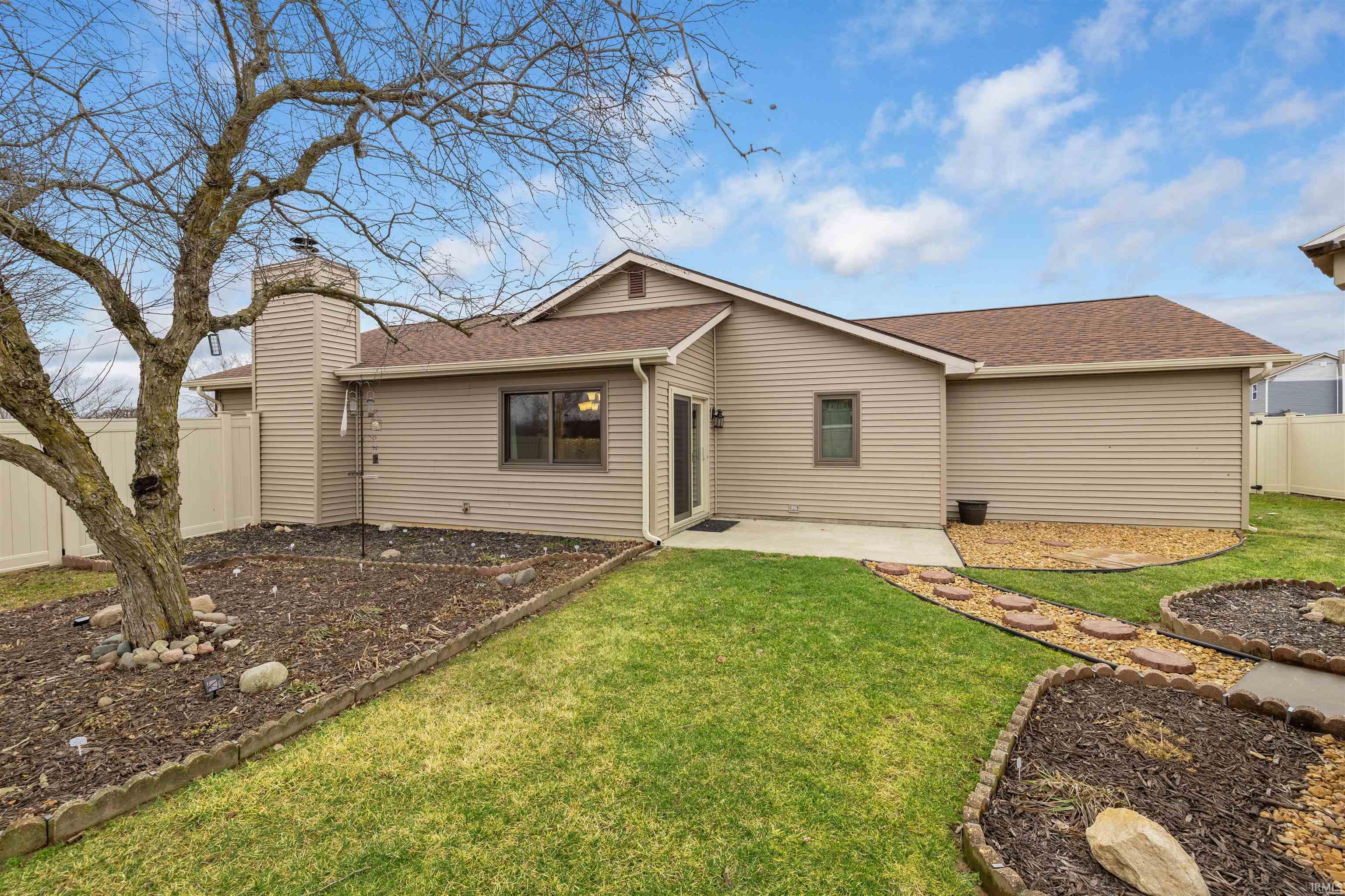 Back of property featuring roof with shingles, a fenced backyard, a patio area, and a chimney