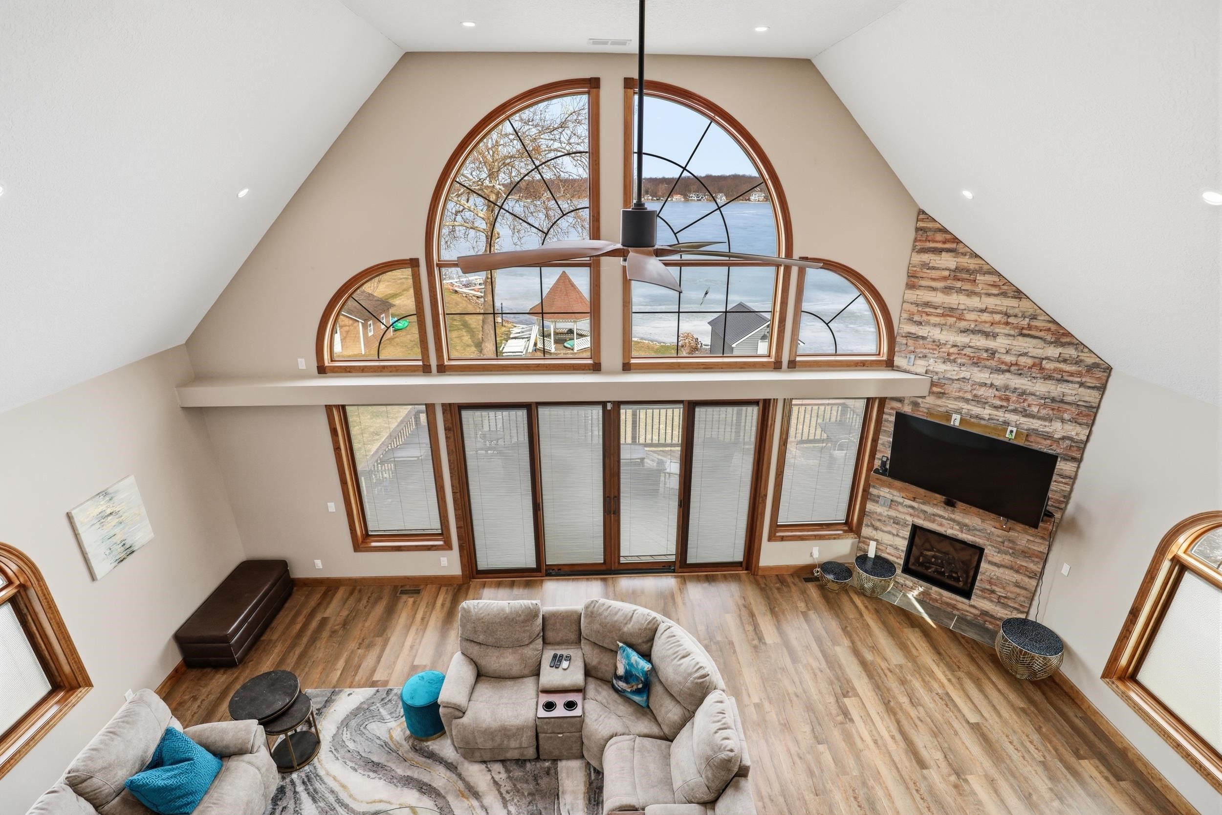 Living room featuring light wood-type flooring, a fireplace, and a high ceiling