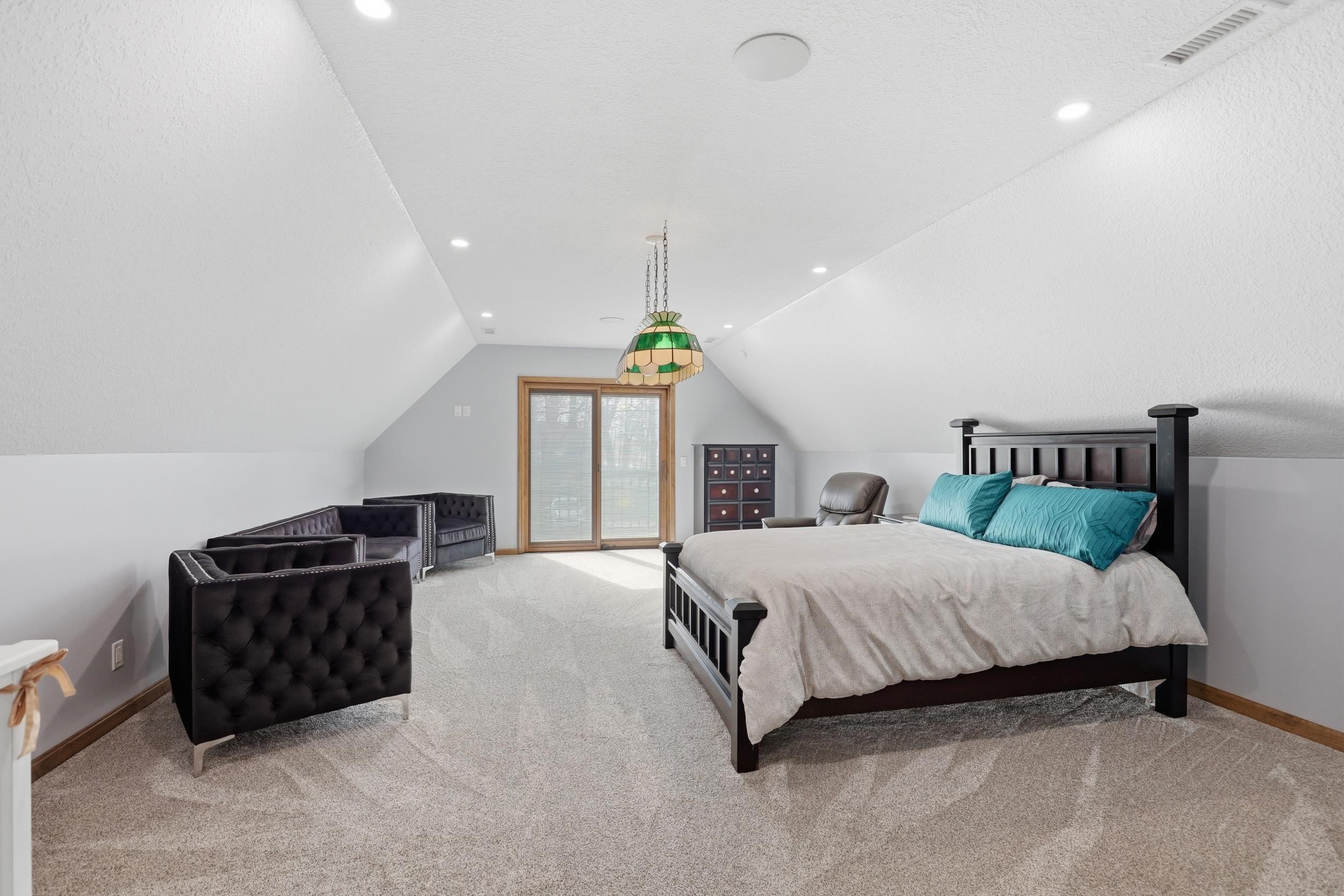 Bedroom with light colored carpet and recessed lighting